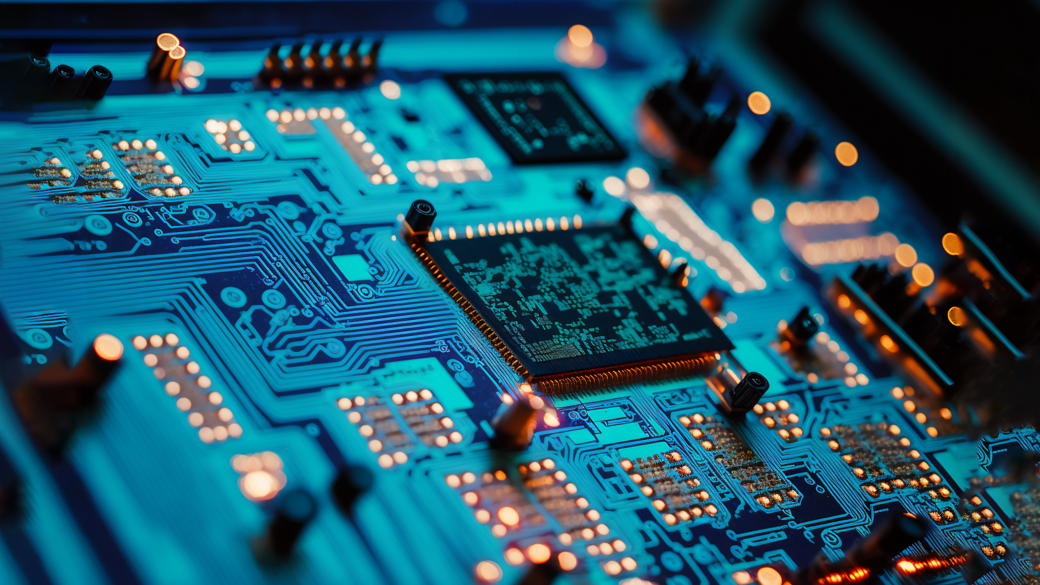 Close-up of a blue circuit board with glowing components HD Wallpaper