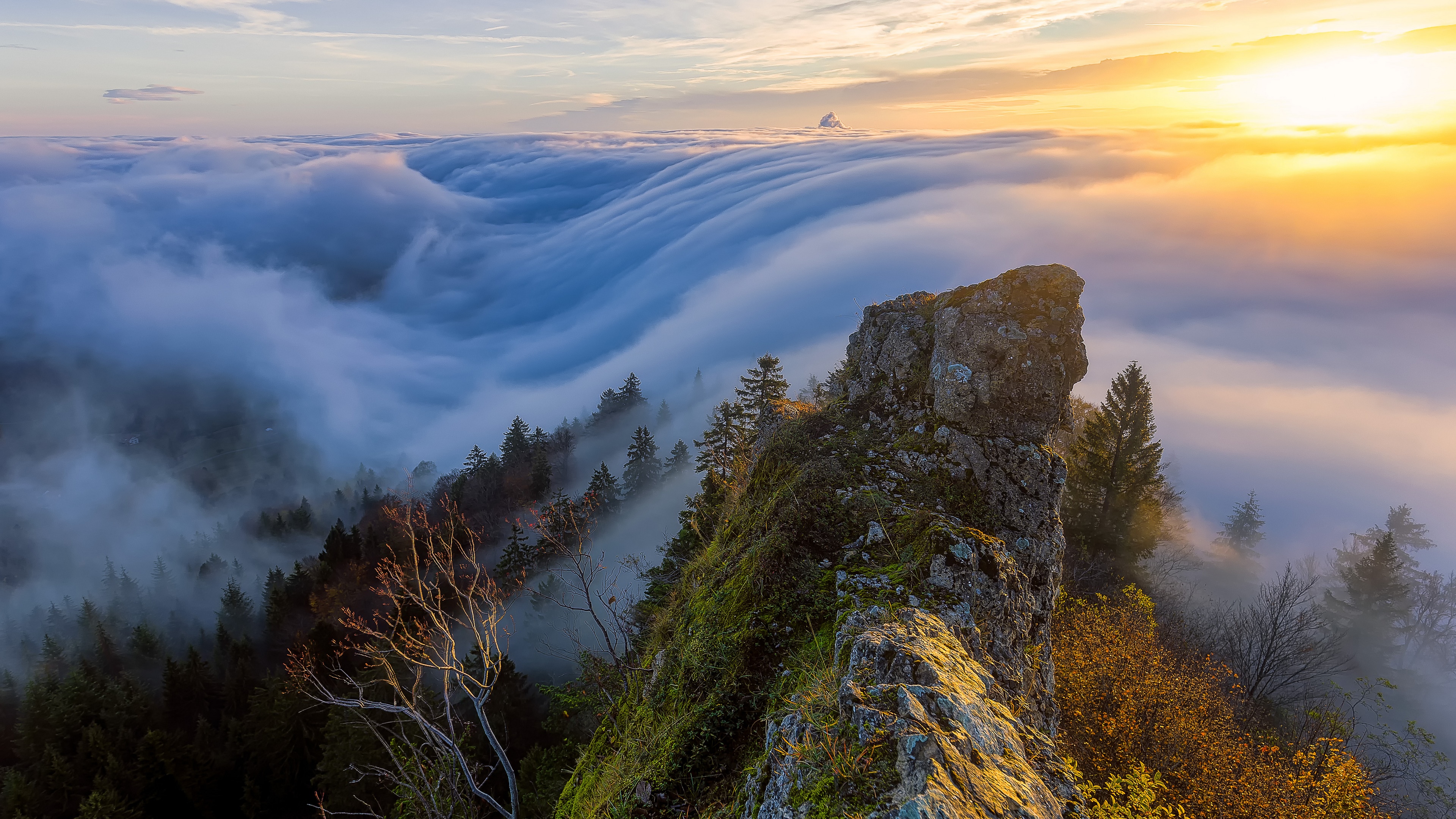 4K sunset over a sea of clouds from a rocky peak HD Wallpaper