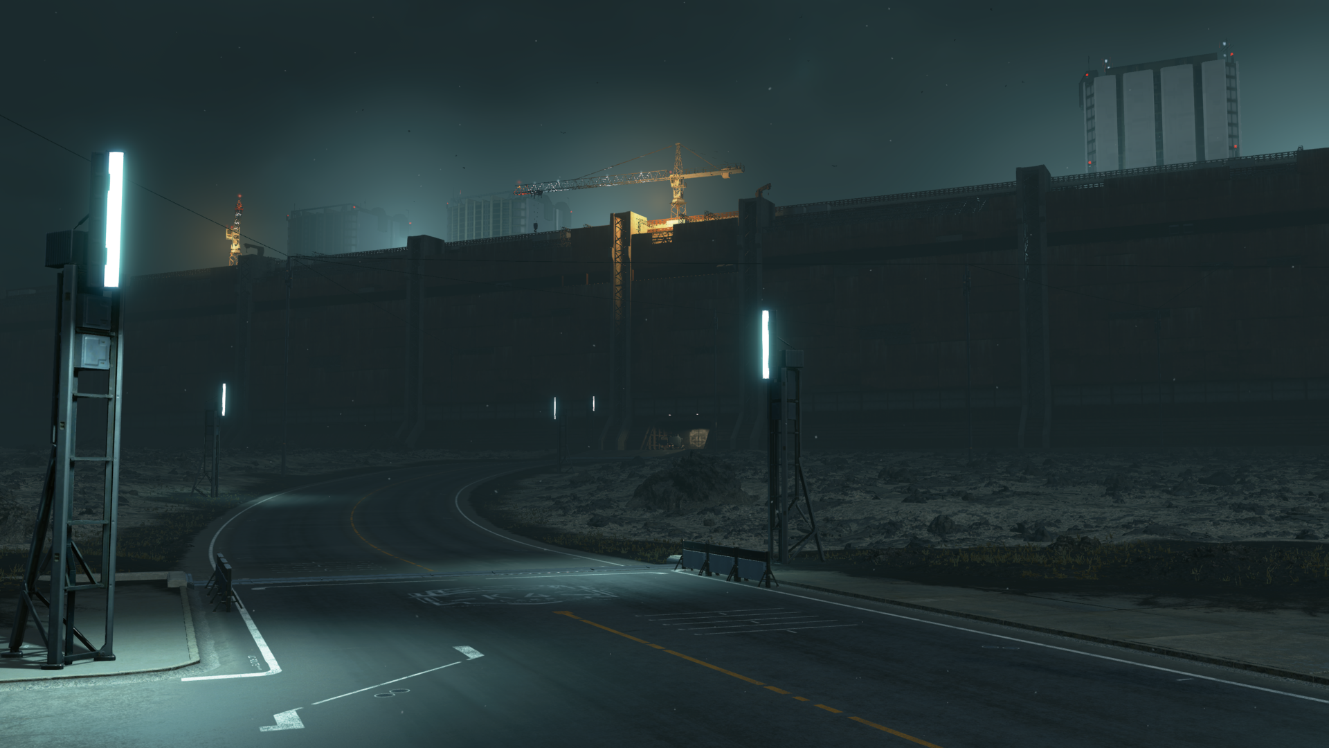 Road leading to a large wall with cranes at night HD Wallpaper