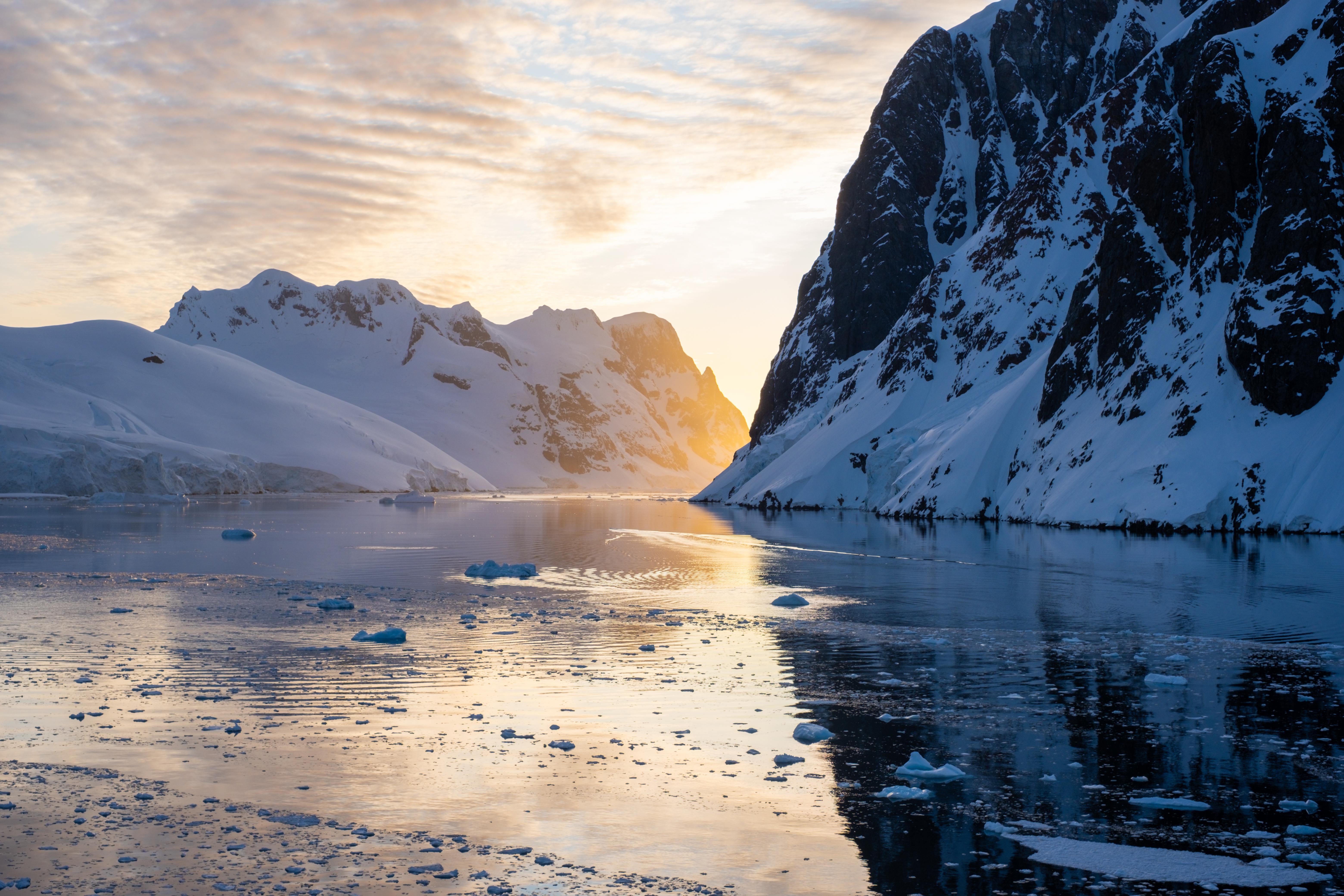 4K Antarctic sunset over icy sea and mountains HD Wallpaper