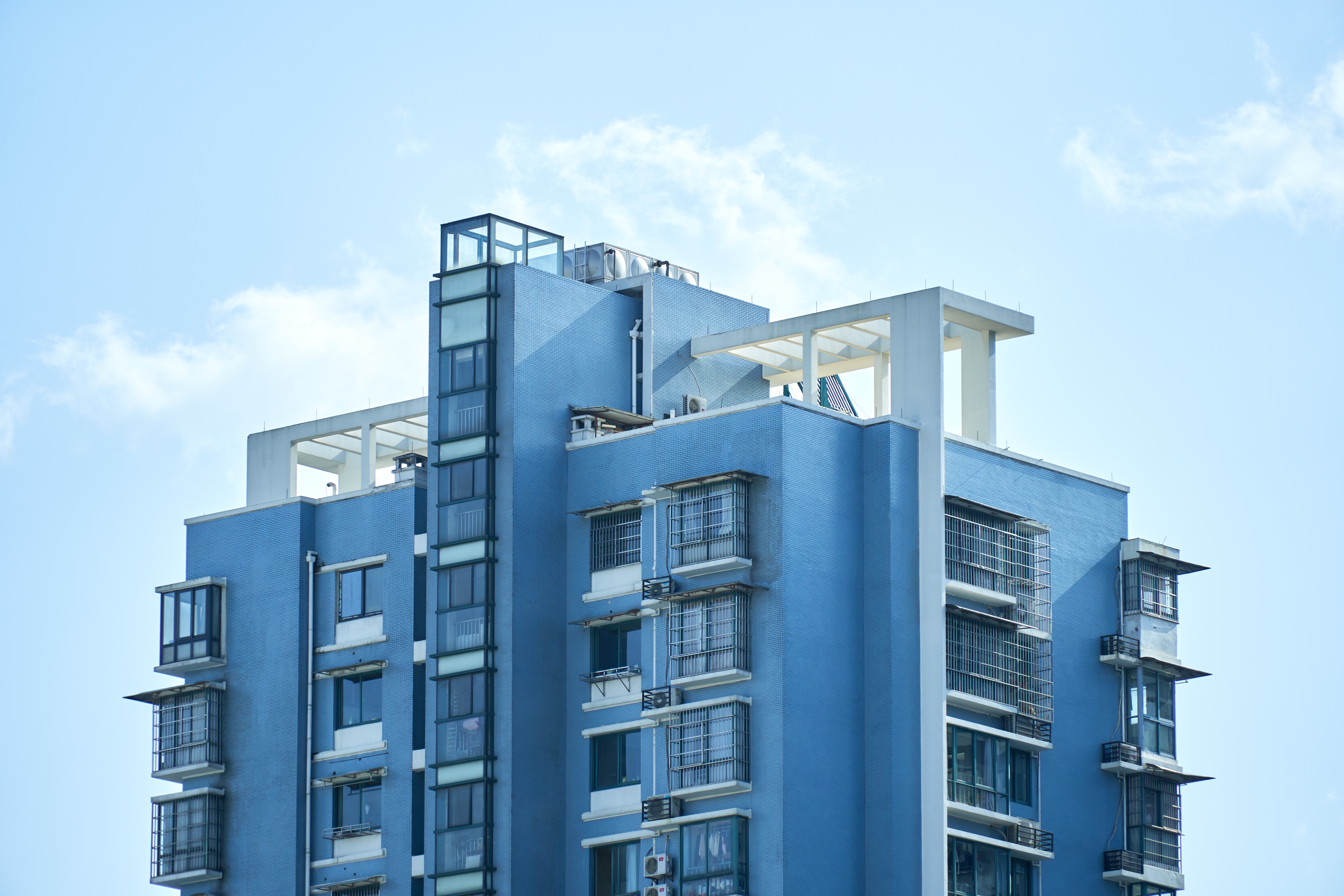 Blue apartment building against a cloudy sky HD Wallpaper