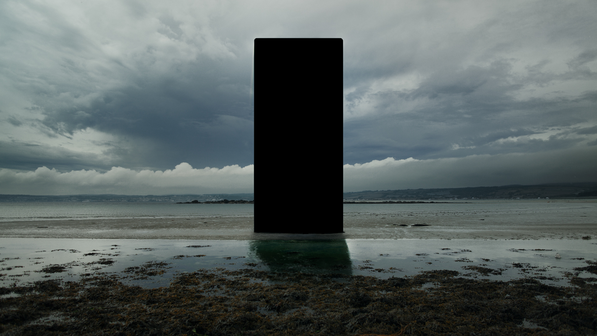 Black monolith on a beach with stormy clouds HD Wallpaper
