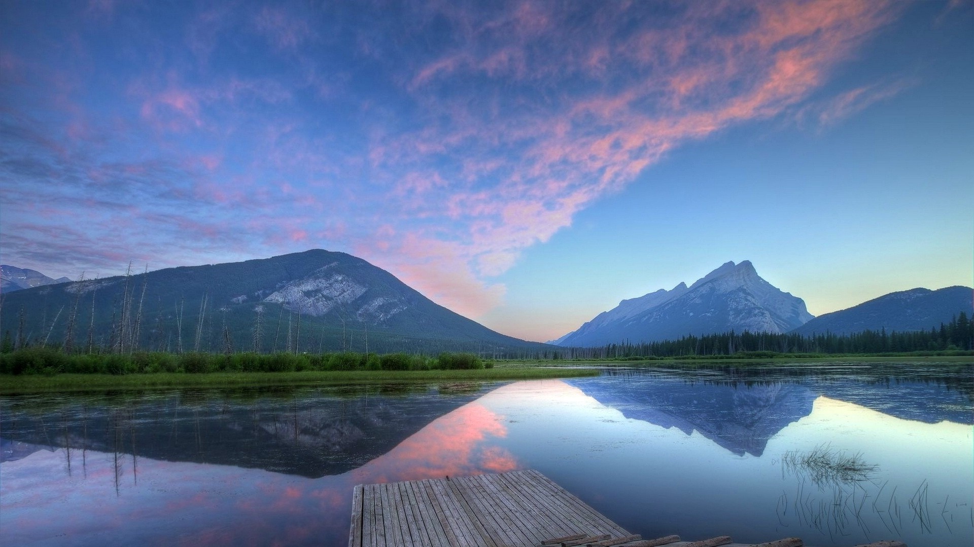 Sunset over mountains reflected in a lake with a wooden dock HD Wallpaper