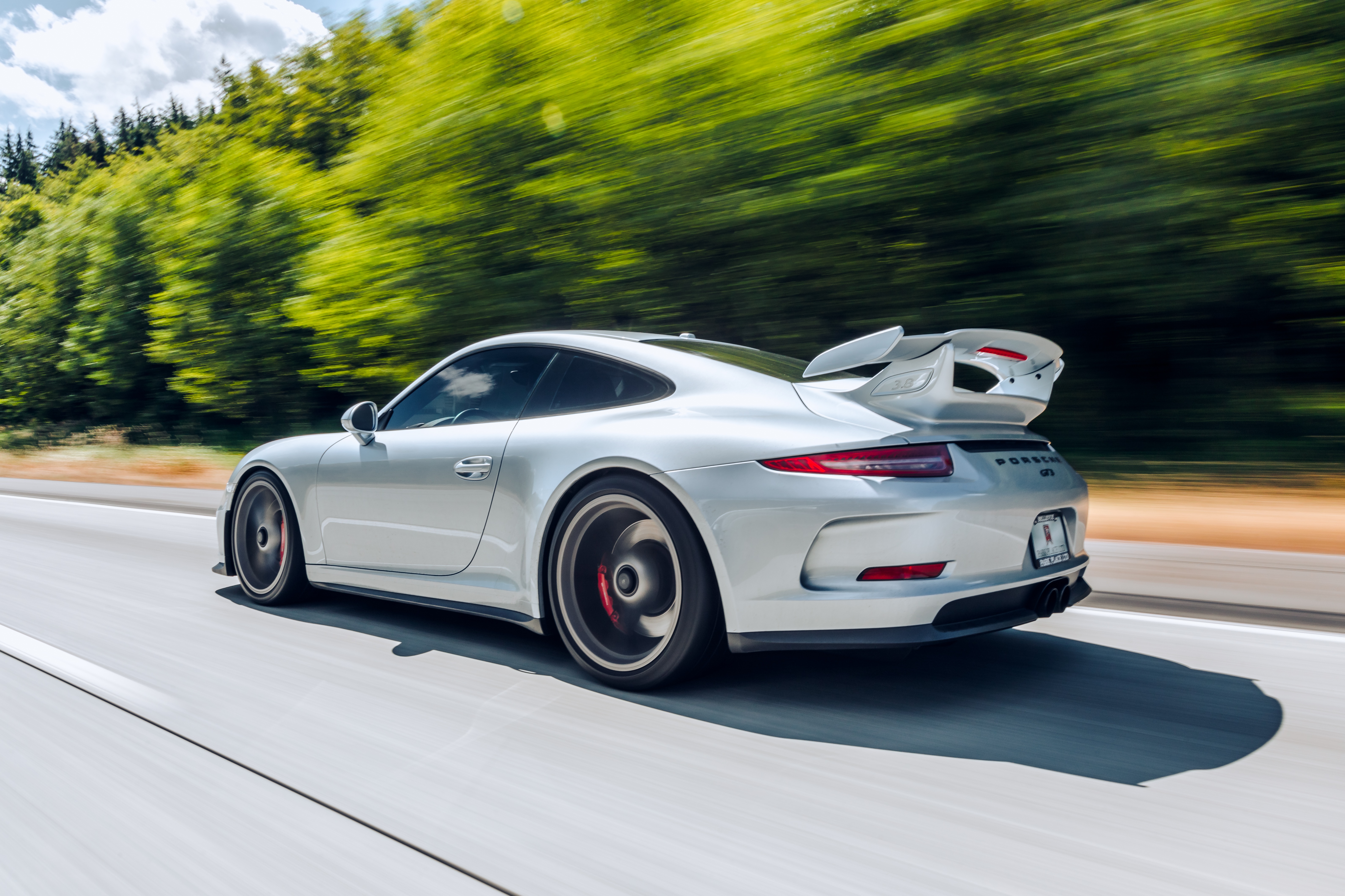 Silver Porsche GT3 driving on a road with trees HD Wallpaper