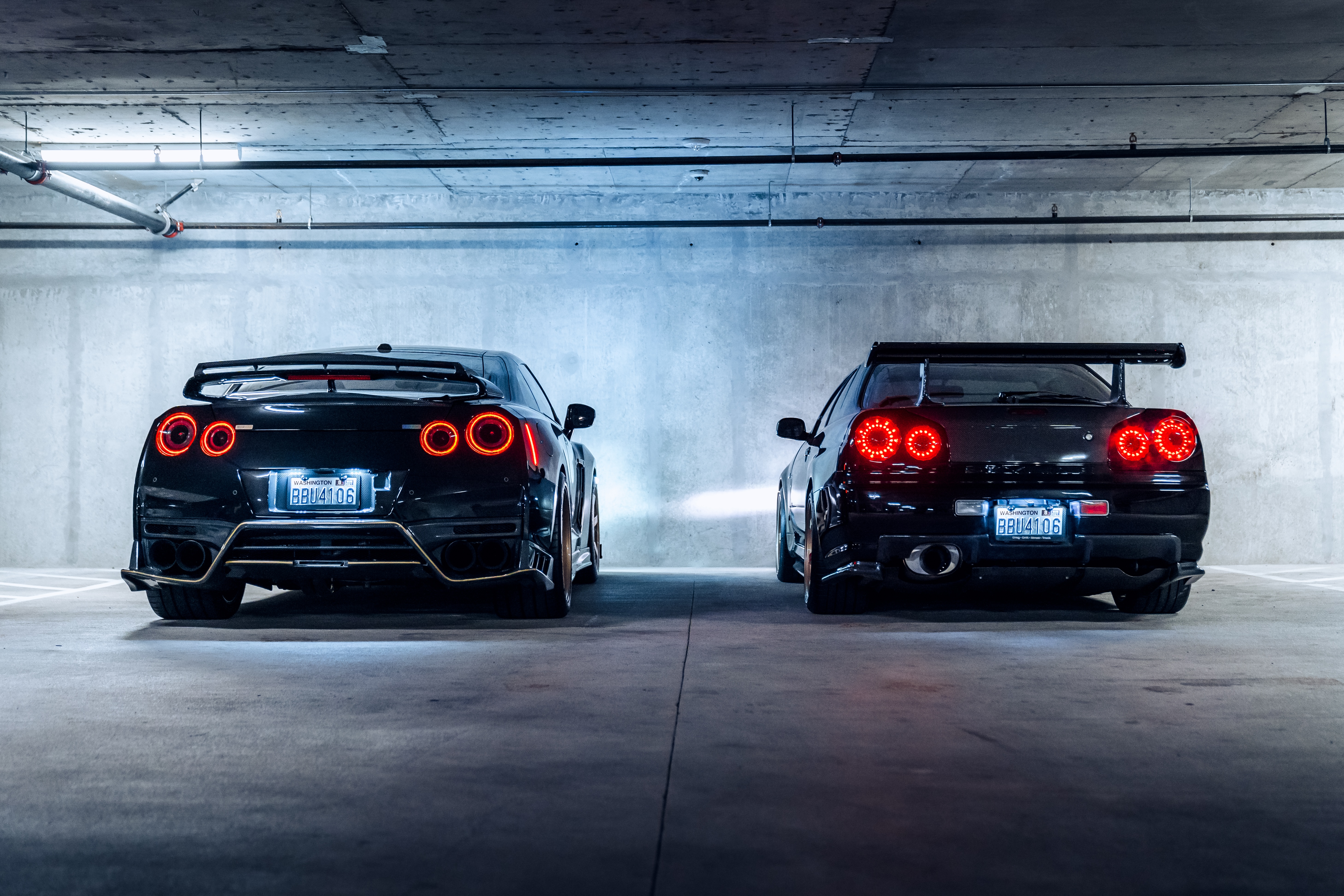 Two Nissan GT-R cars in a parking garage HD Wallpaper