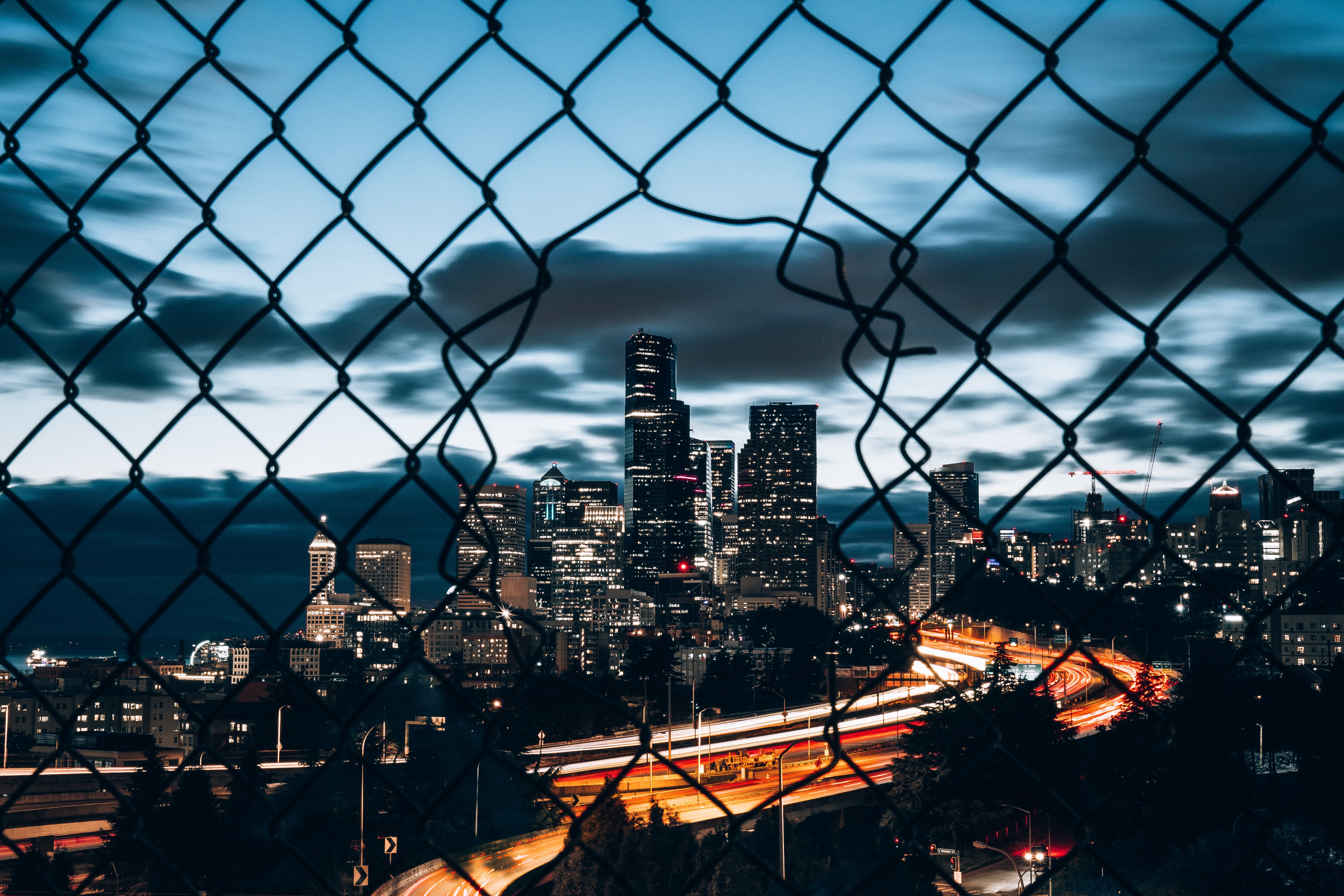 4K Seattle Cityscape at Night Through Chain Link Fence HD Wallpaper
