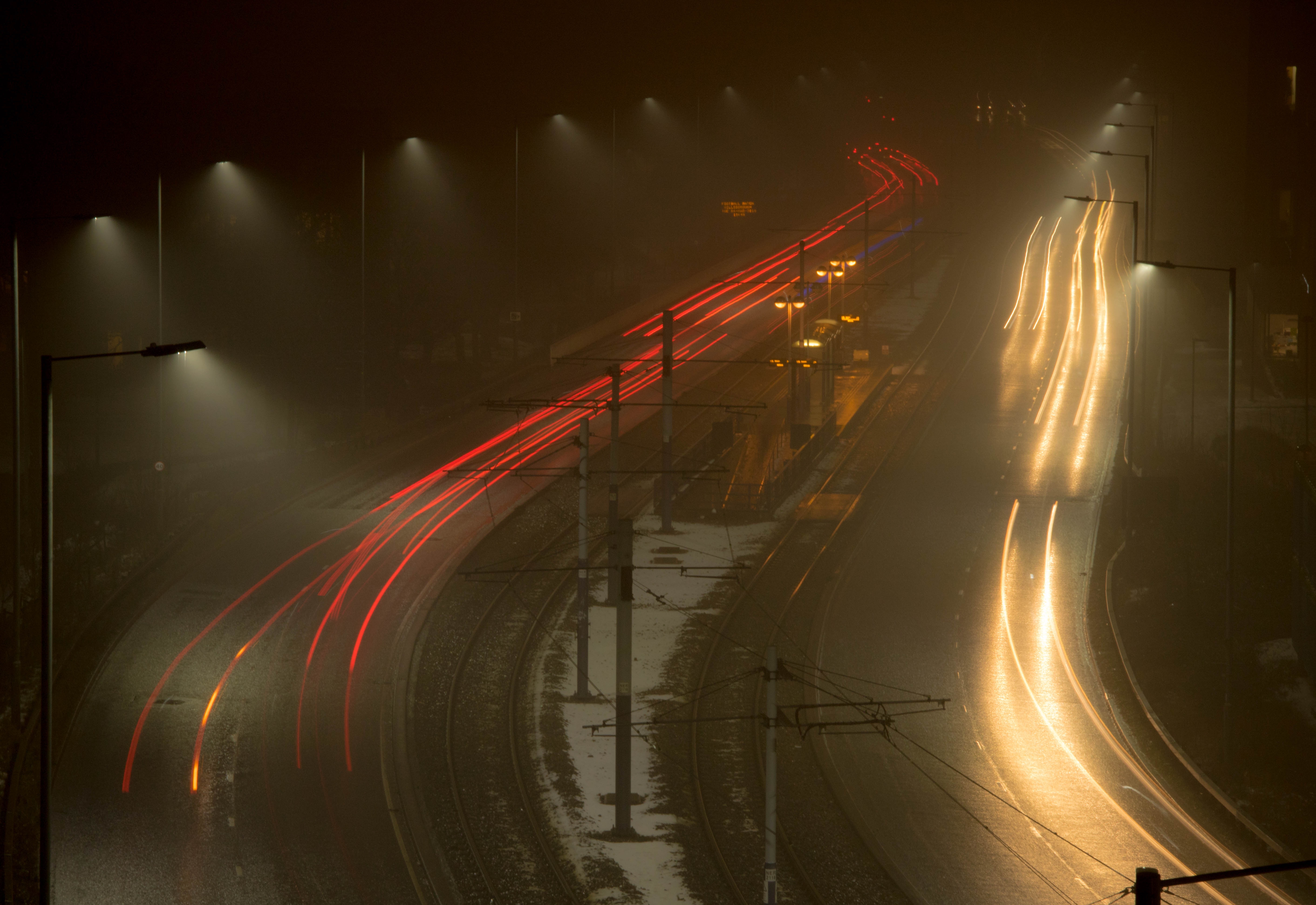 Long exposure of car lights on a misty road at night HD Wallpaper