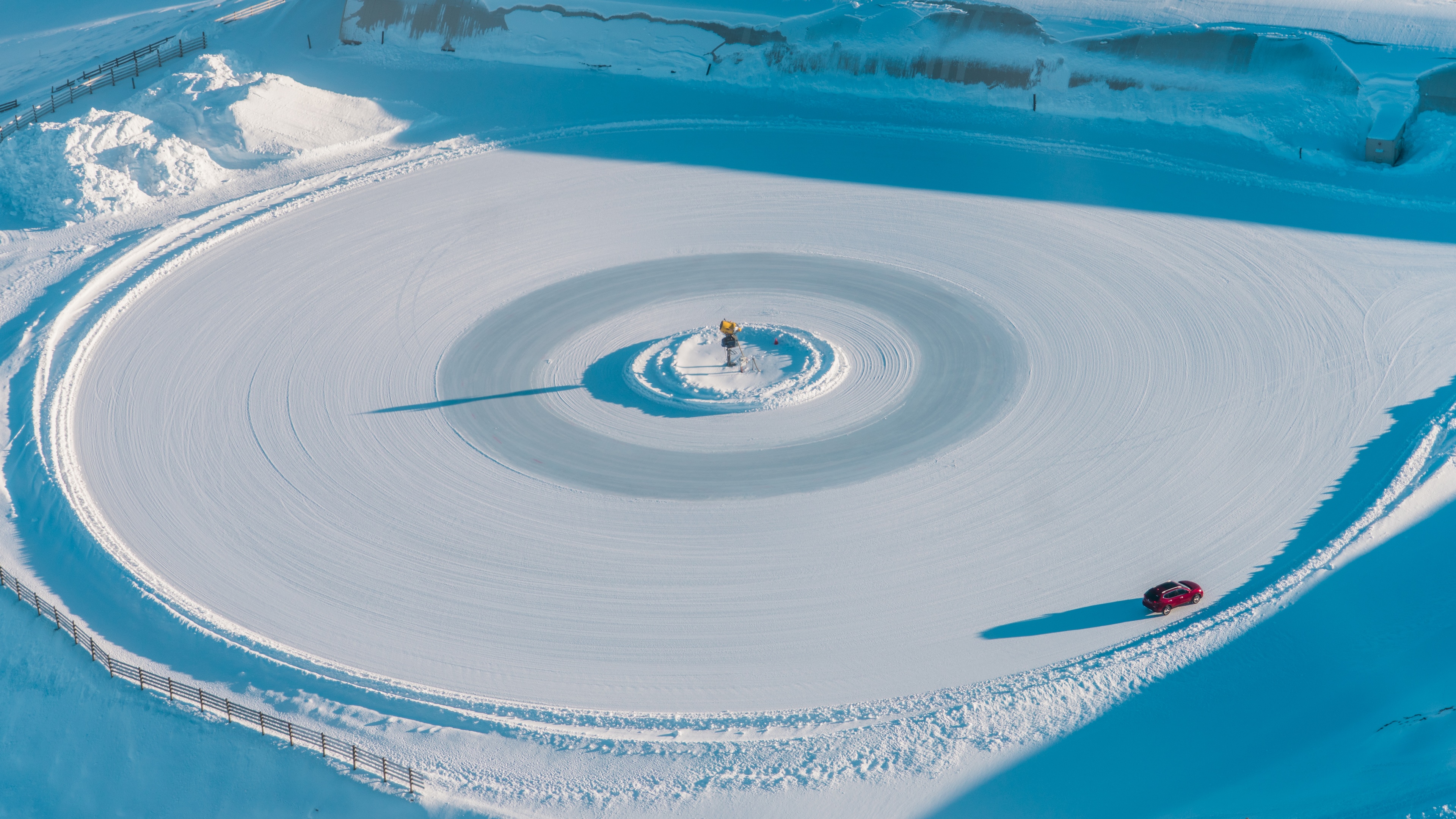 Car driving on a snowy circle in New Zealand HD Wallpaper