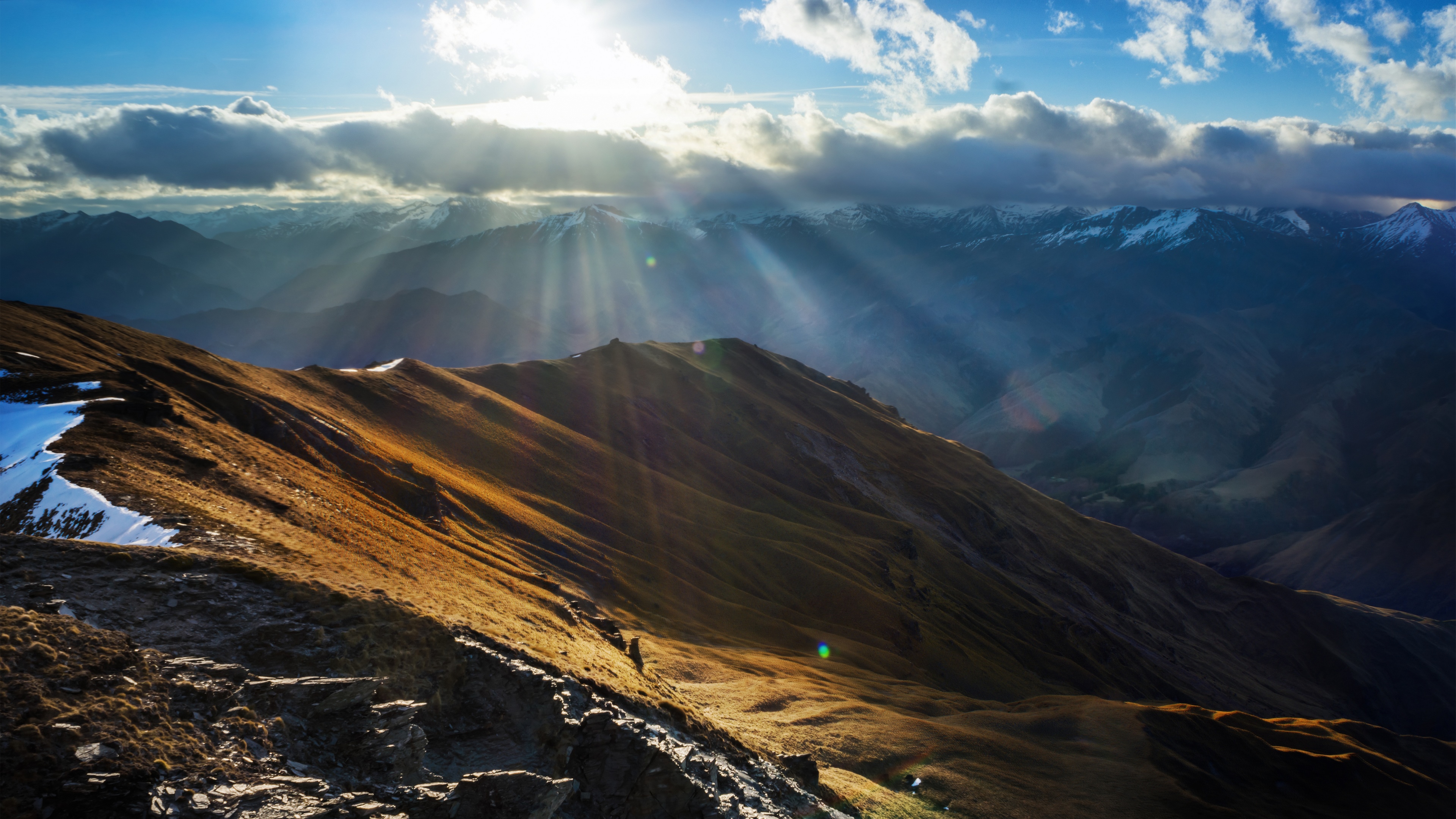 Sunlight beams over snow-capped mountains in New Zealand HD Wallpaper