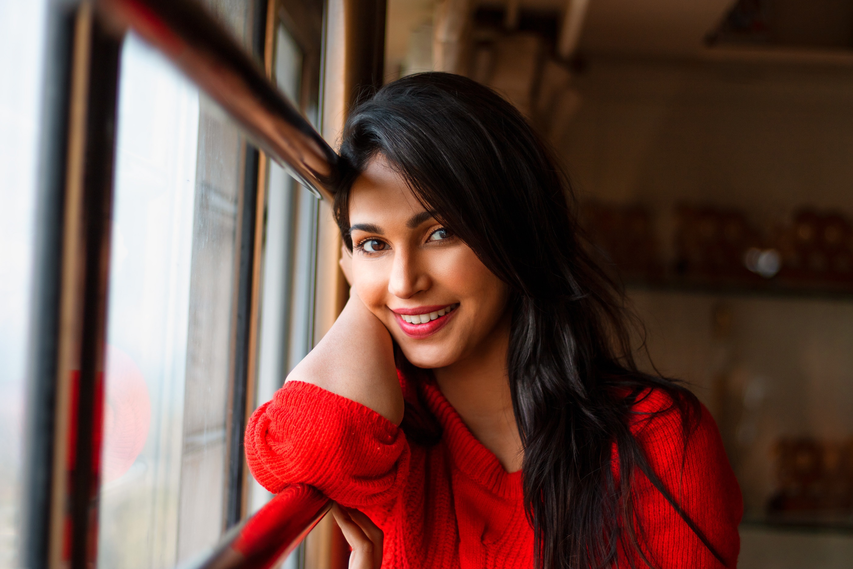 Woman with black hair smiling by the window HD Wallpaper