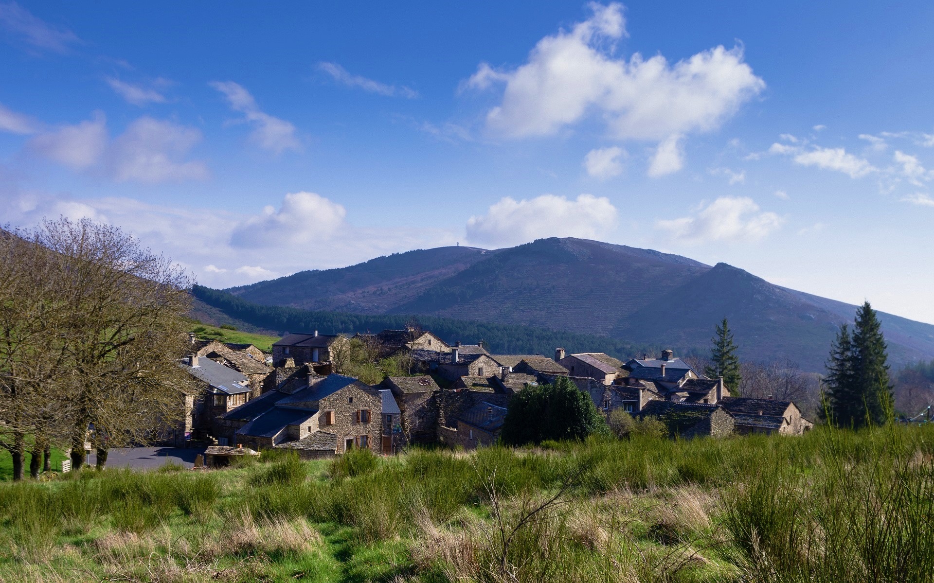 Village nestled in a valley with mountains HD Wallpaper