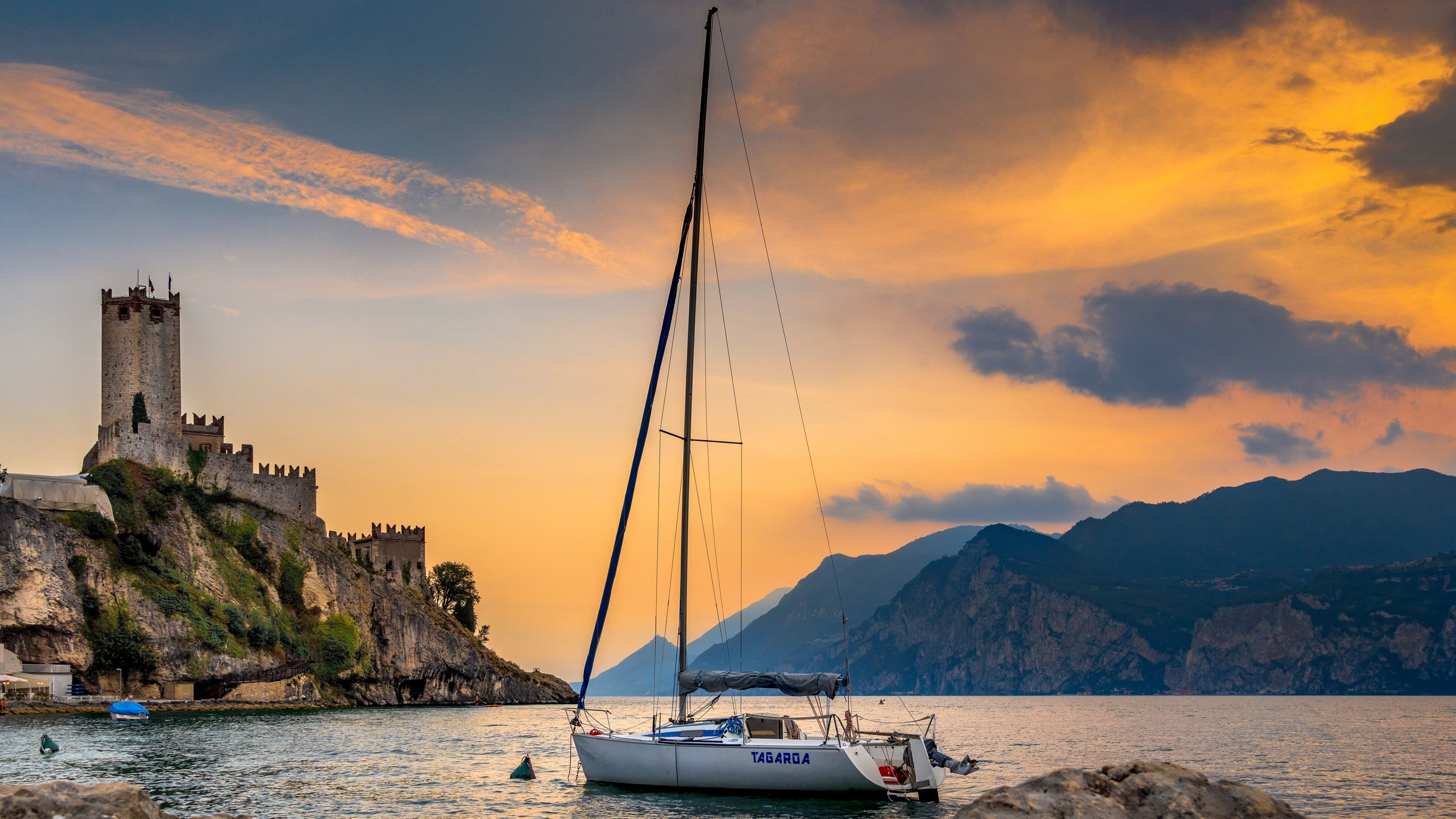 Castle and sailboat on Lake Garda at sunset HD Wallpaper