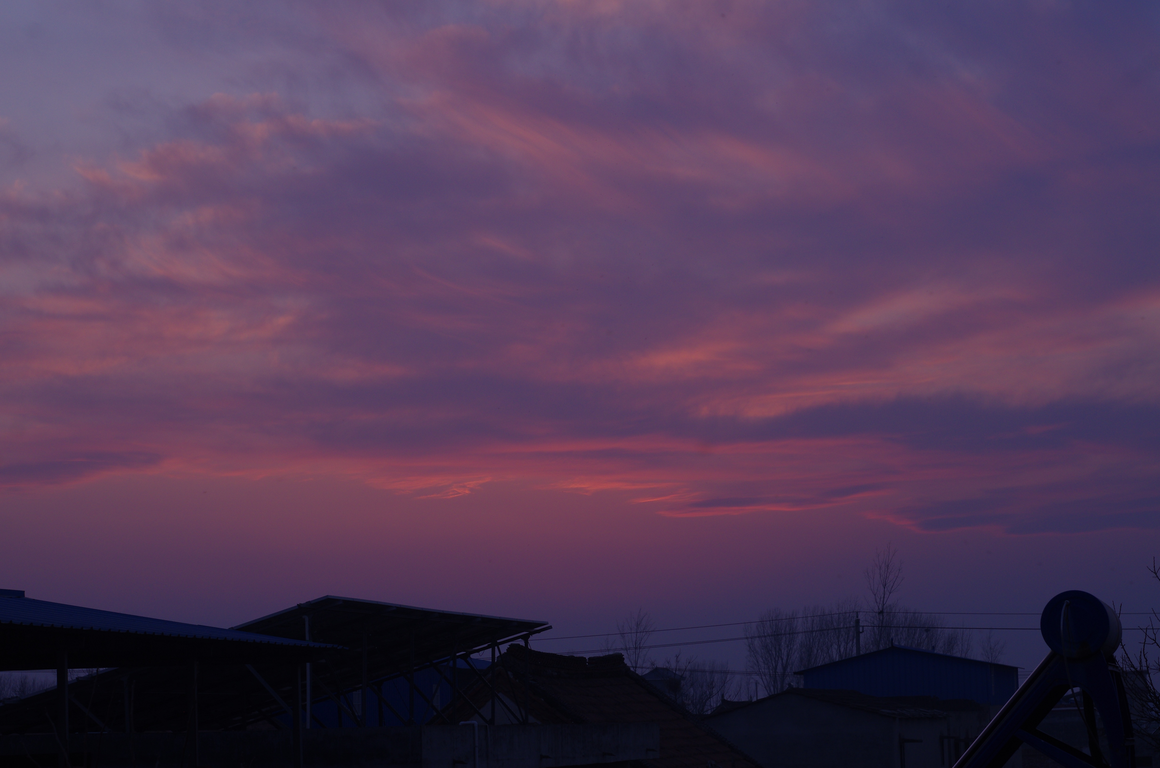 Purple and pink clouds at dusk over buildings HD Wallpaper