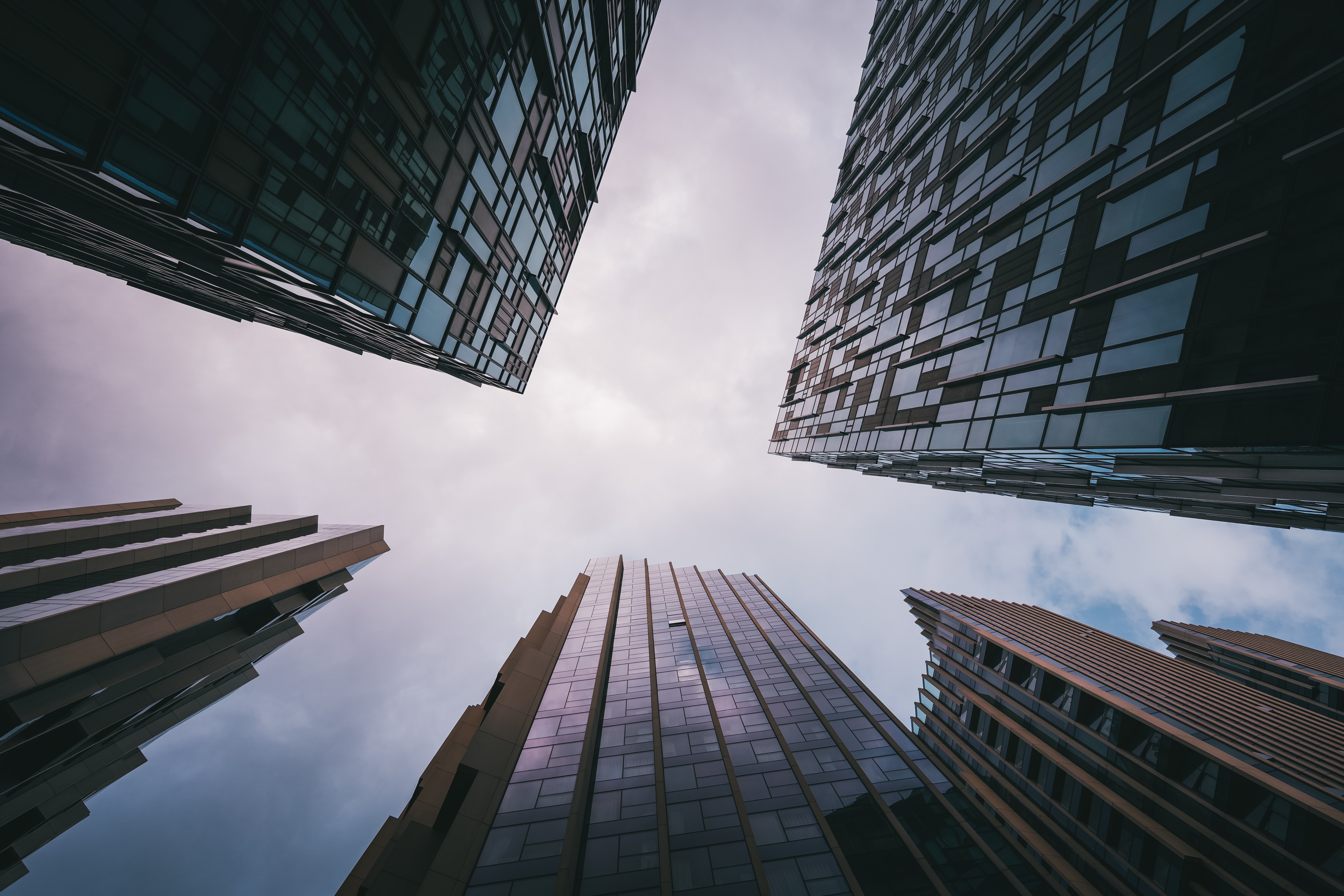 Four skyscrapers viewed from below against a cloudy sky HD Wallpaper