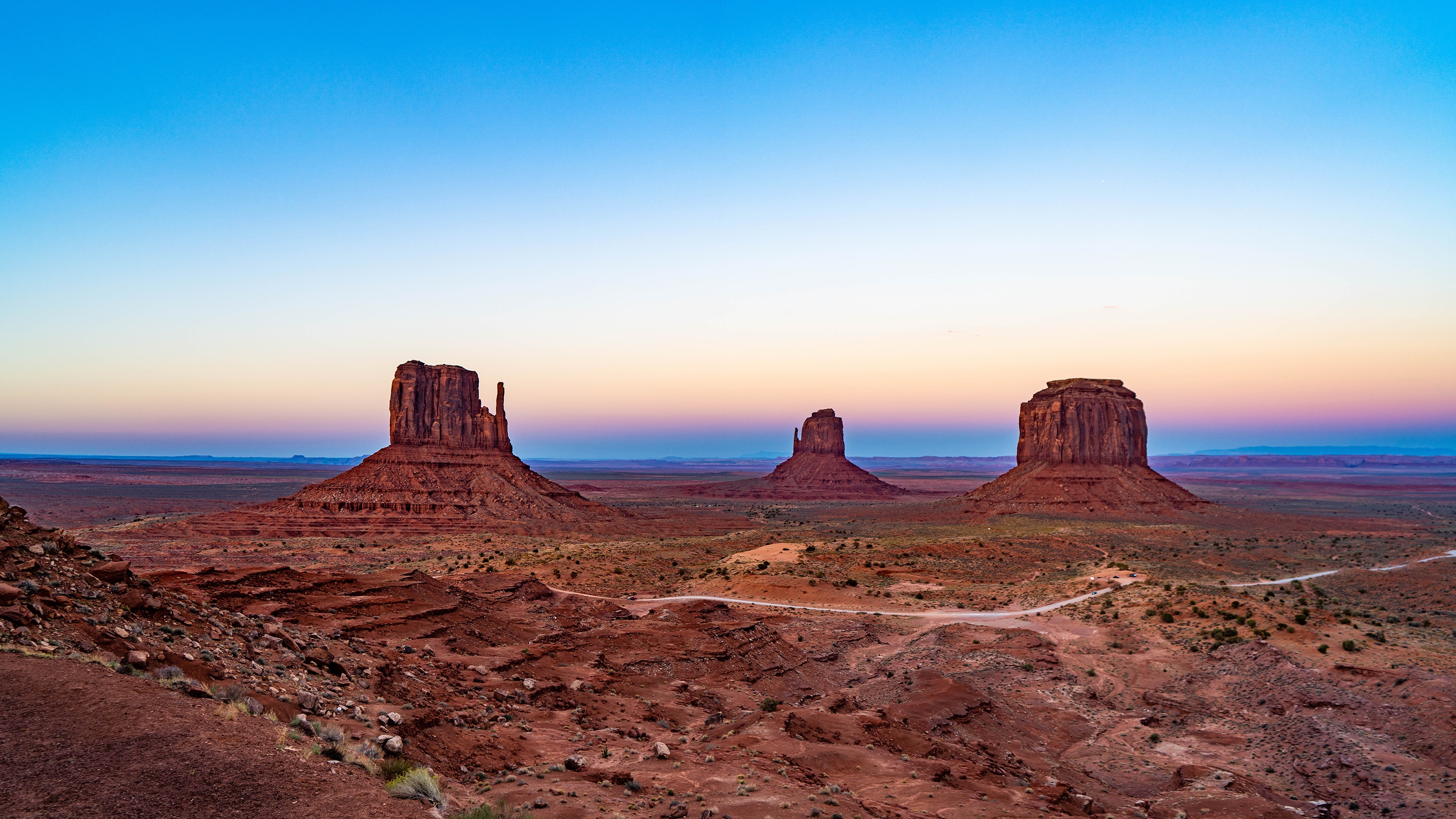 Monument Valley at sunrise with mesas and desert landscape HD Wallpaper