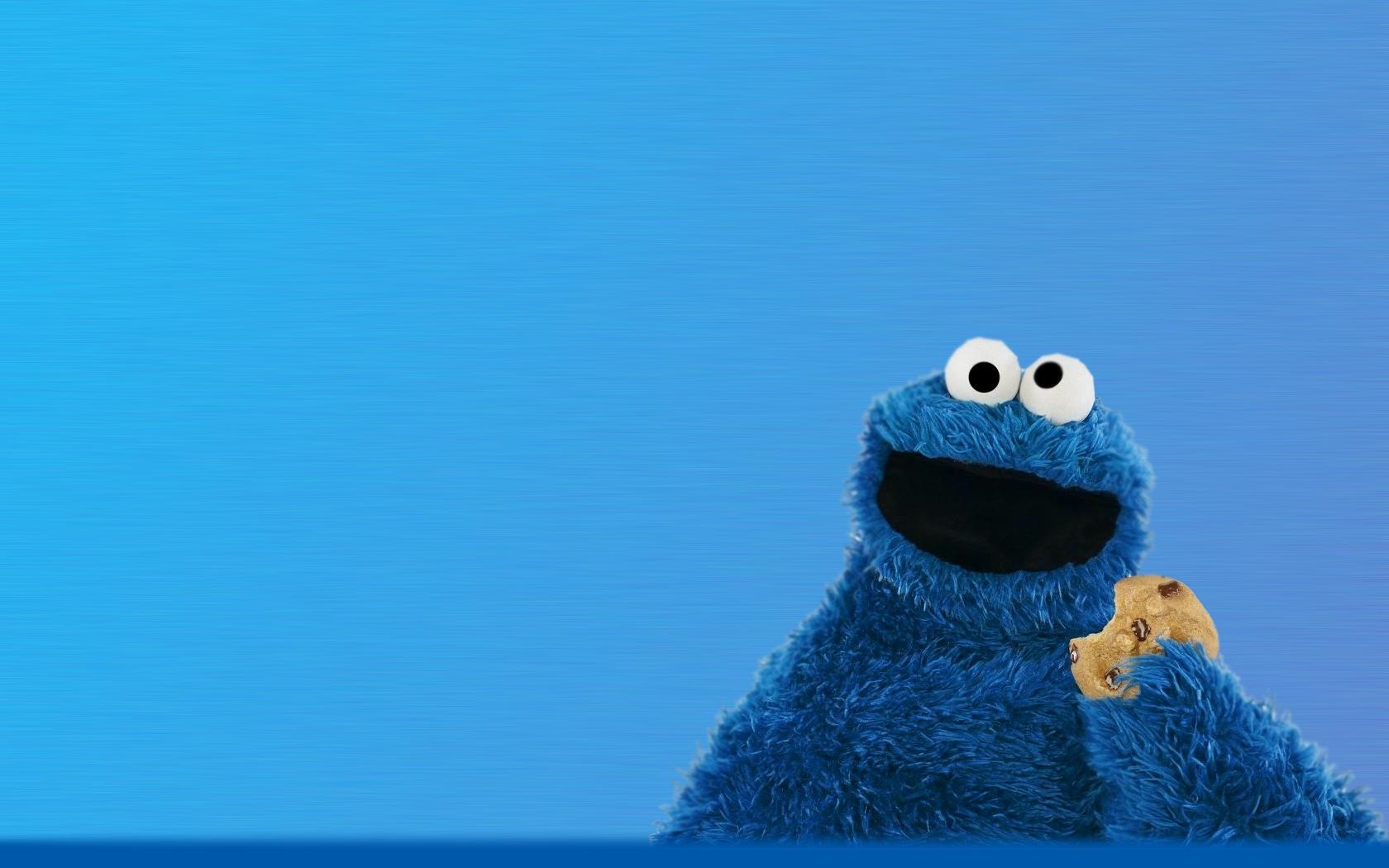 Cookie Monster eating a cookie on a blue background HD Wallpaper