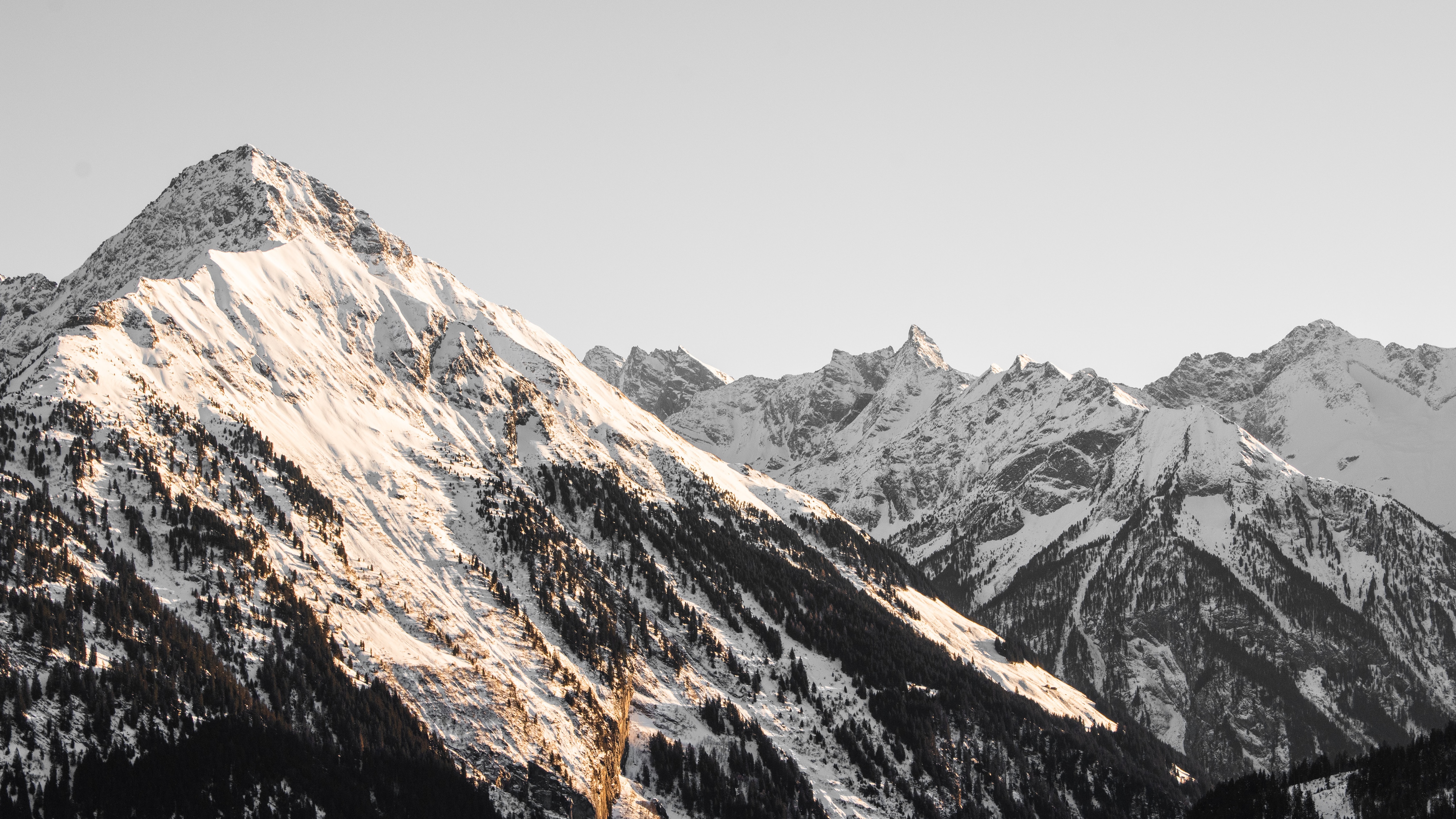 Snow-covered mountains under a clear sky HD Wallpaper