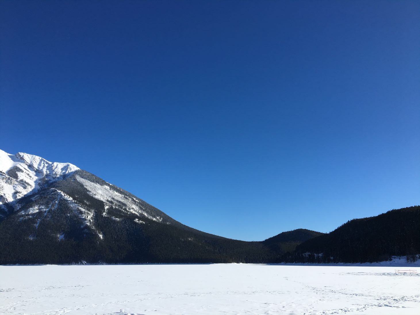 Snowy mountains and frozen lake under a clear blue sky HD Wallpaper