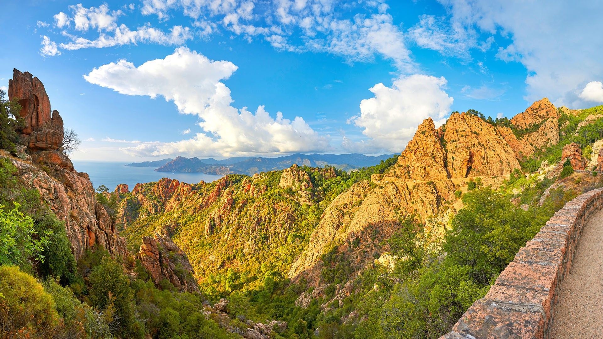 Rocky mountains and sea under a blue sky with clouds HD Wallpaper