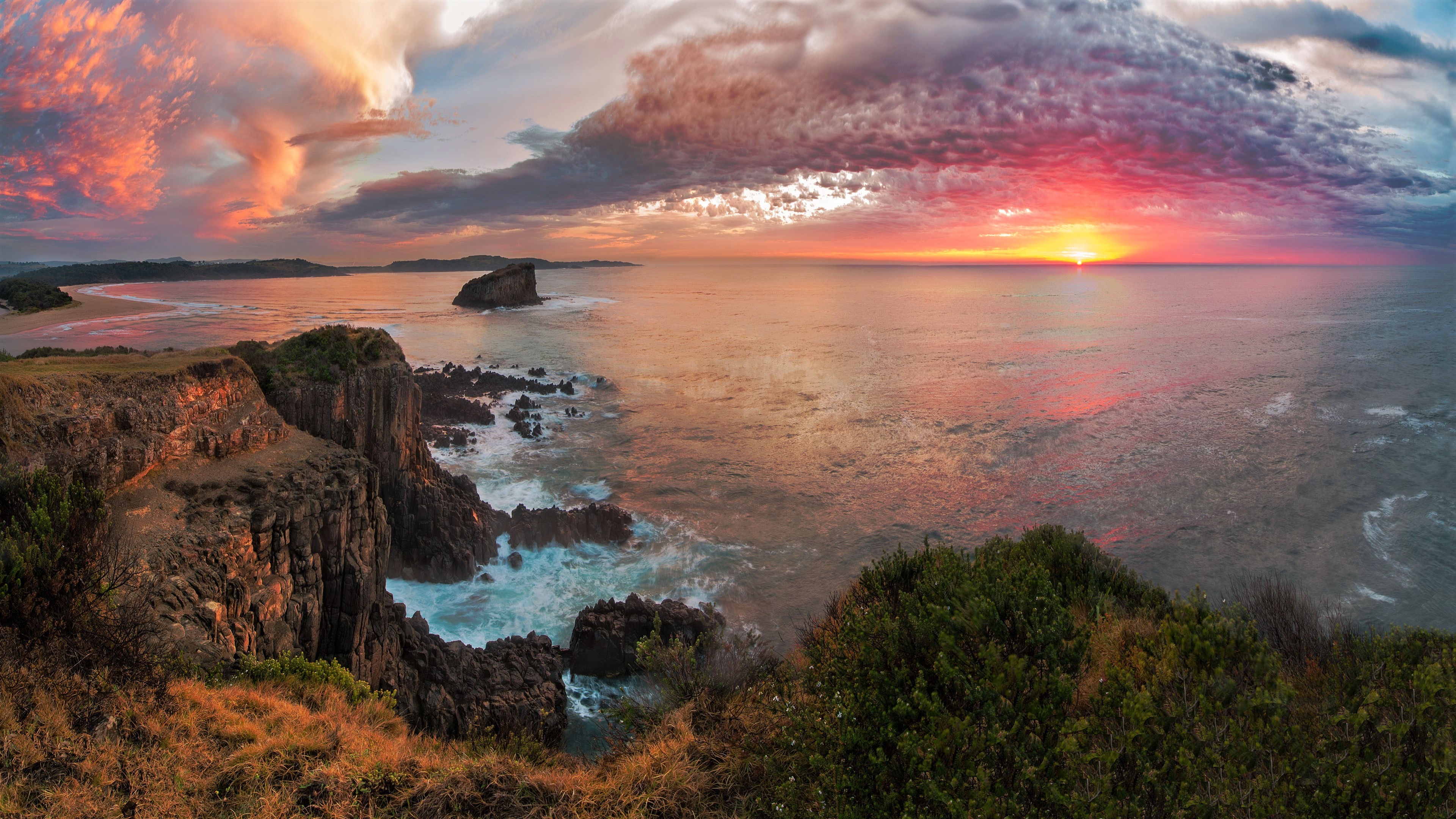 4K sunset over the sea with dramatic clouds and cliffs HD Wallpaper