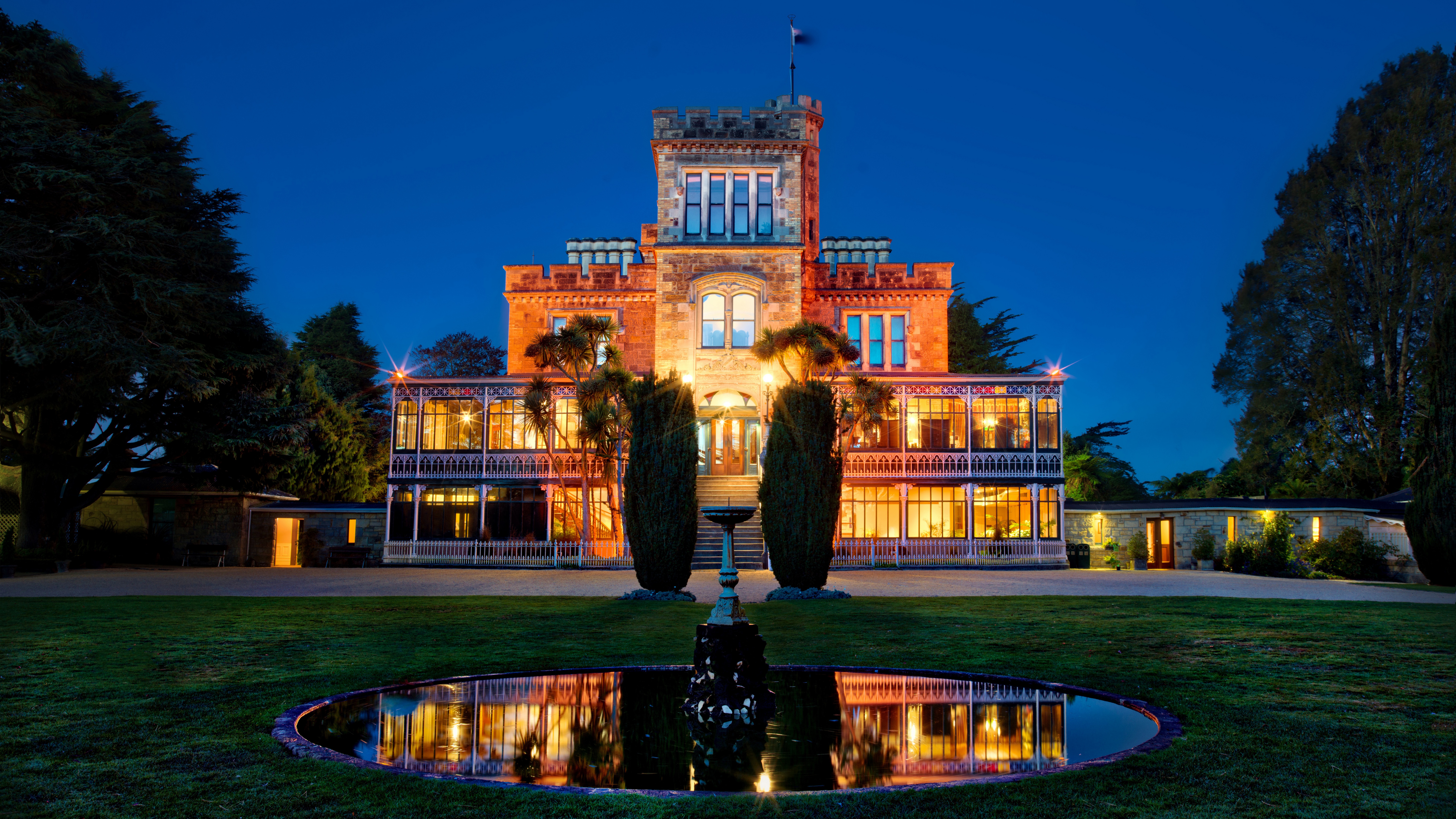 Castle at night with fountain and reflection HD Wallpaper