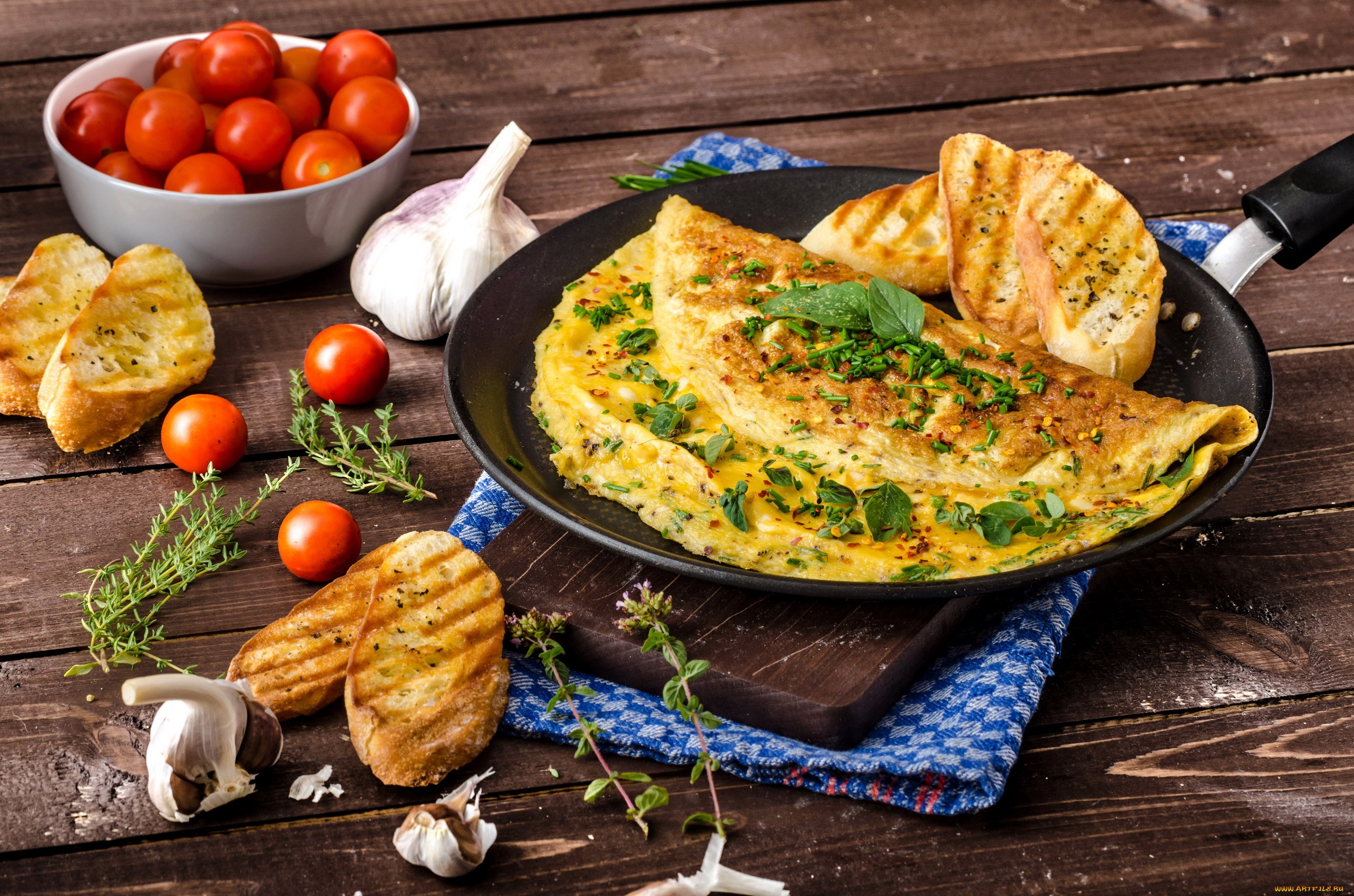 Omelette with herbs, toast, tomatoes, and garlic on a wooden table HD Wallpaper