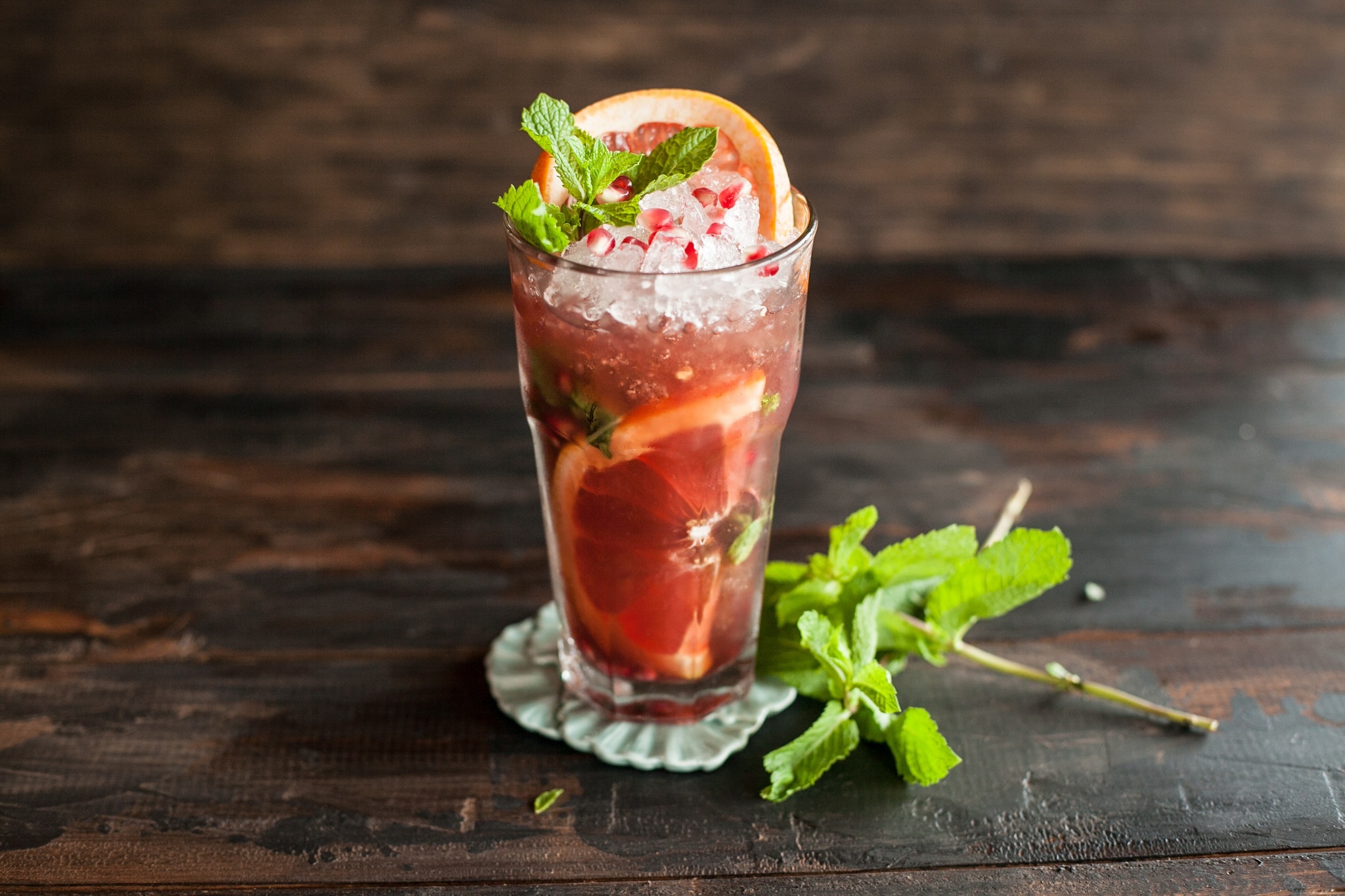 Grapefruit and mint cocktail with ice and pomegranate seeds HD Wallpaper
