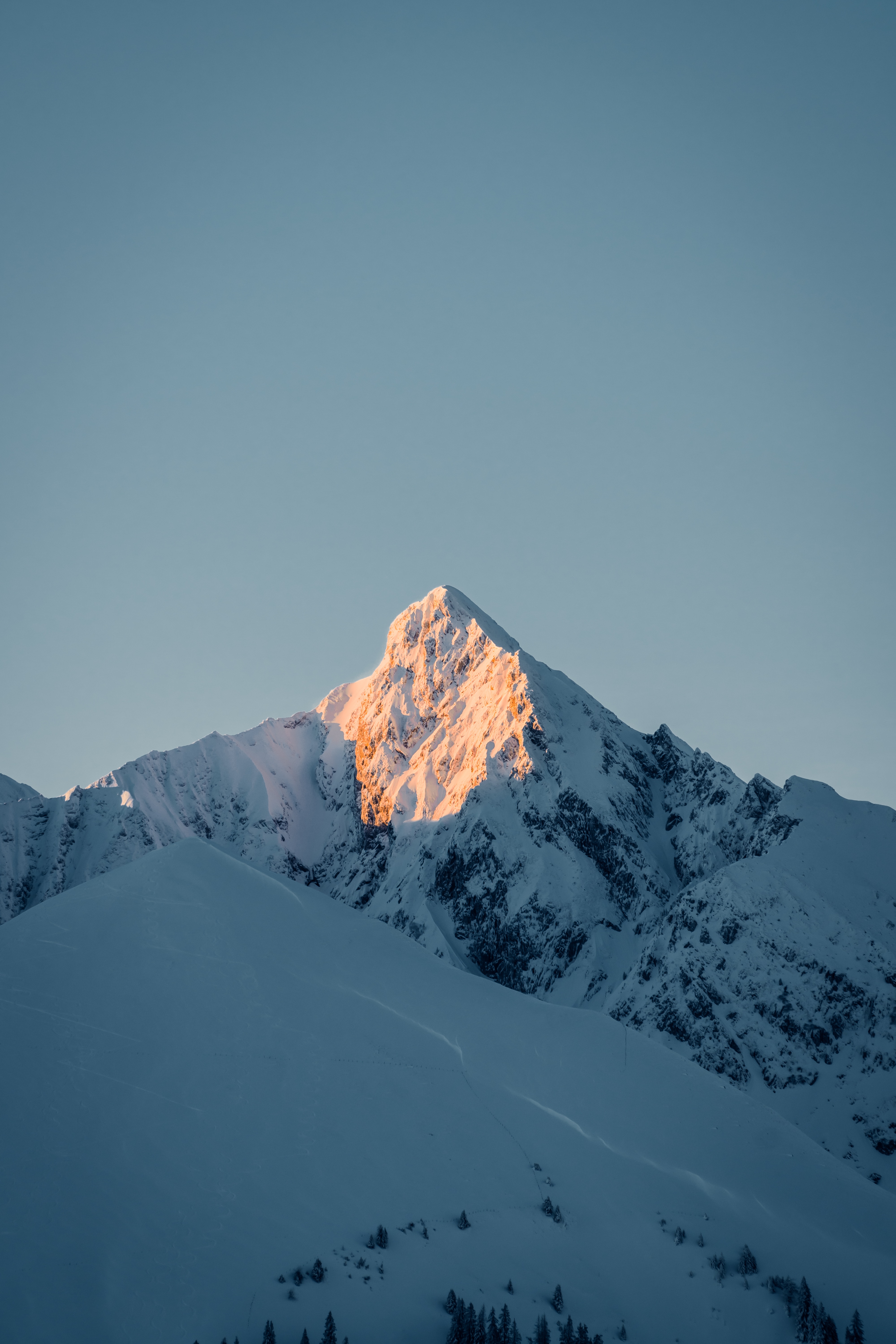 Snowy mountain top illuminated by sunlight HD Phone Wallpaper