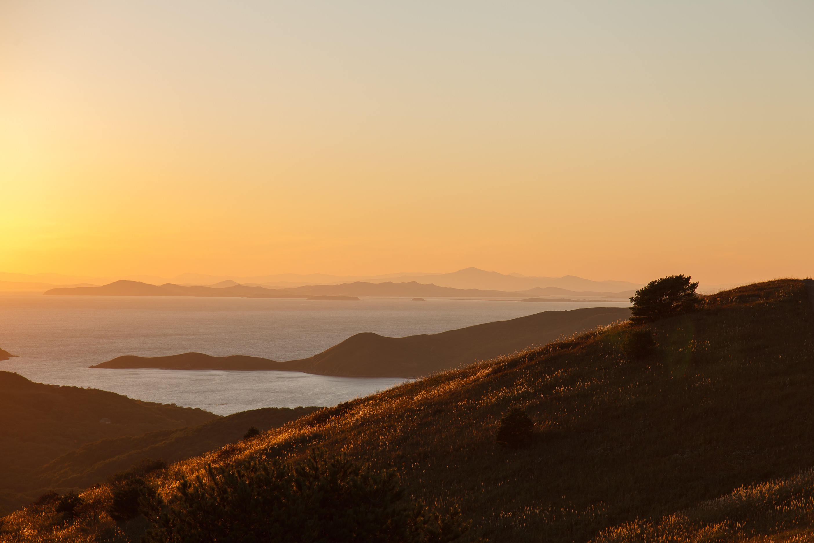 Sunset over the sea and hills HD Wallpaper