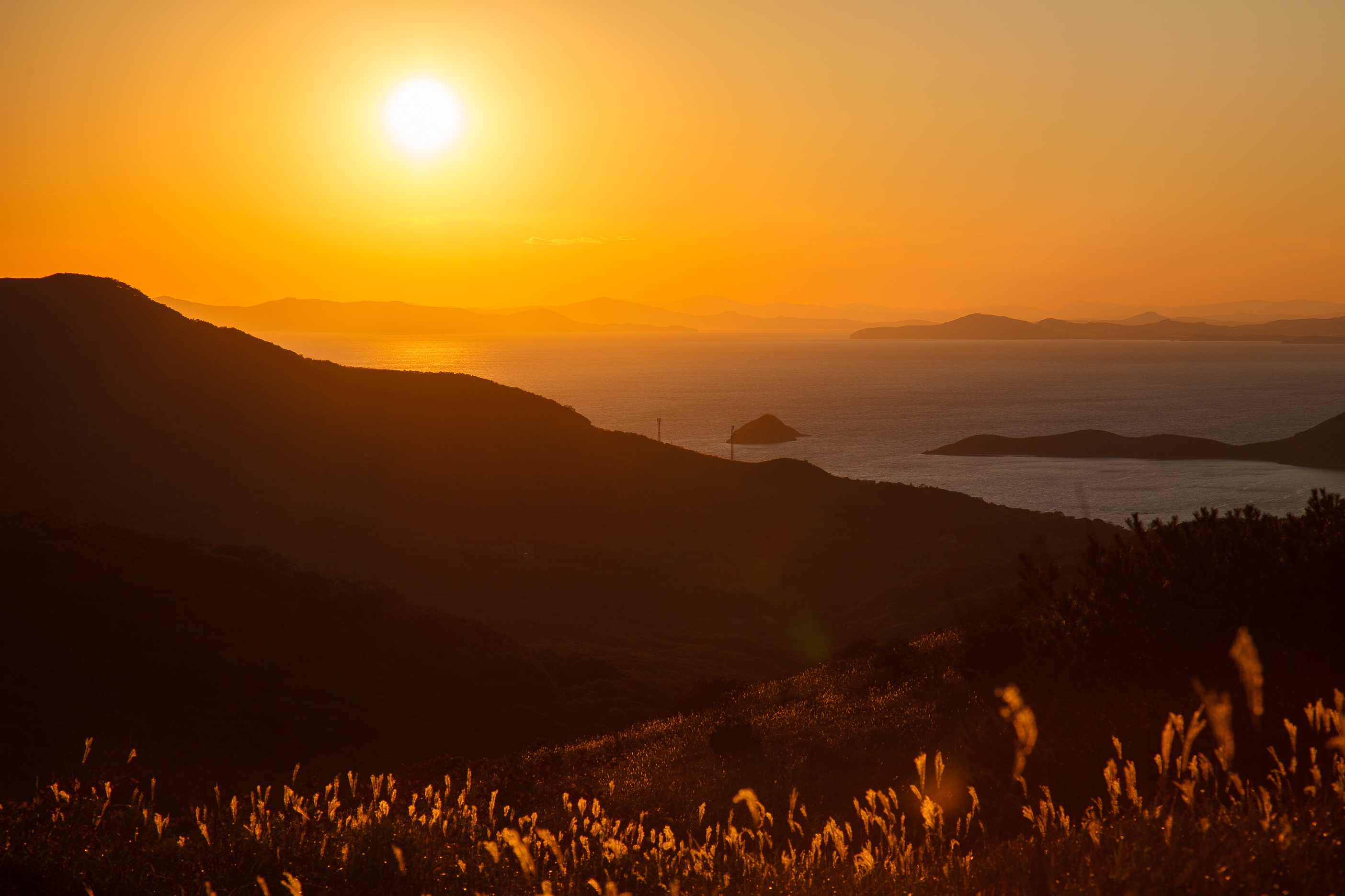 Sunset over the ocean with islands and mountains HD Wallpaper