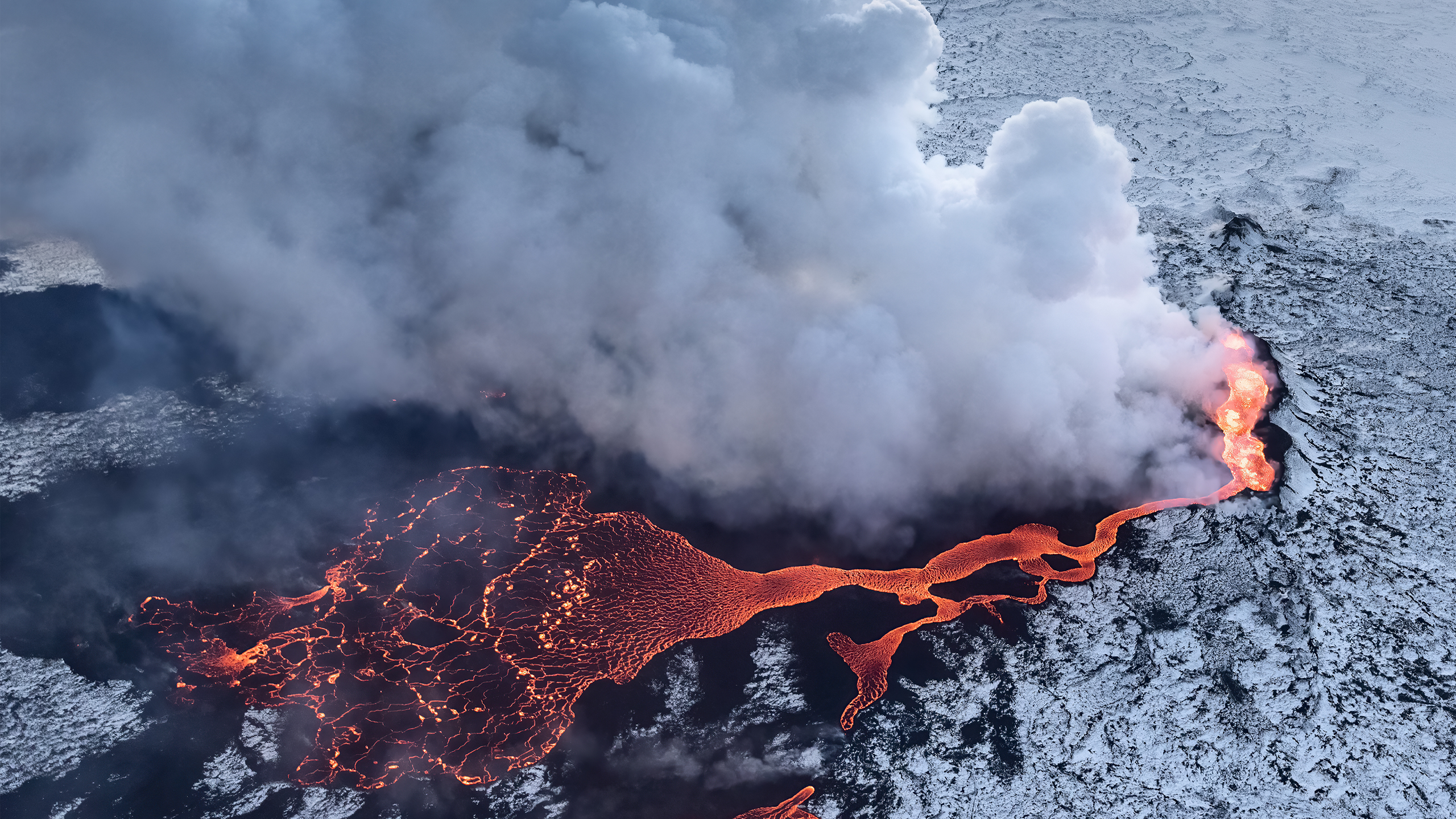 Aerial view of a volcano erupting with lava and smoke HD Wallpaper