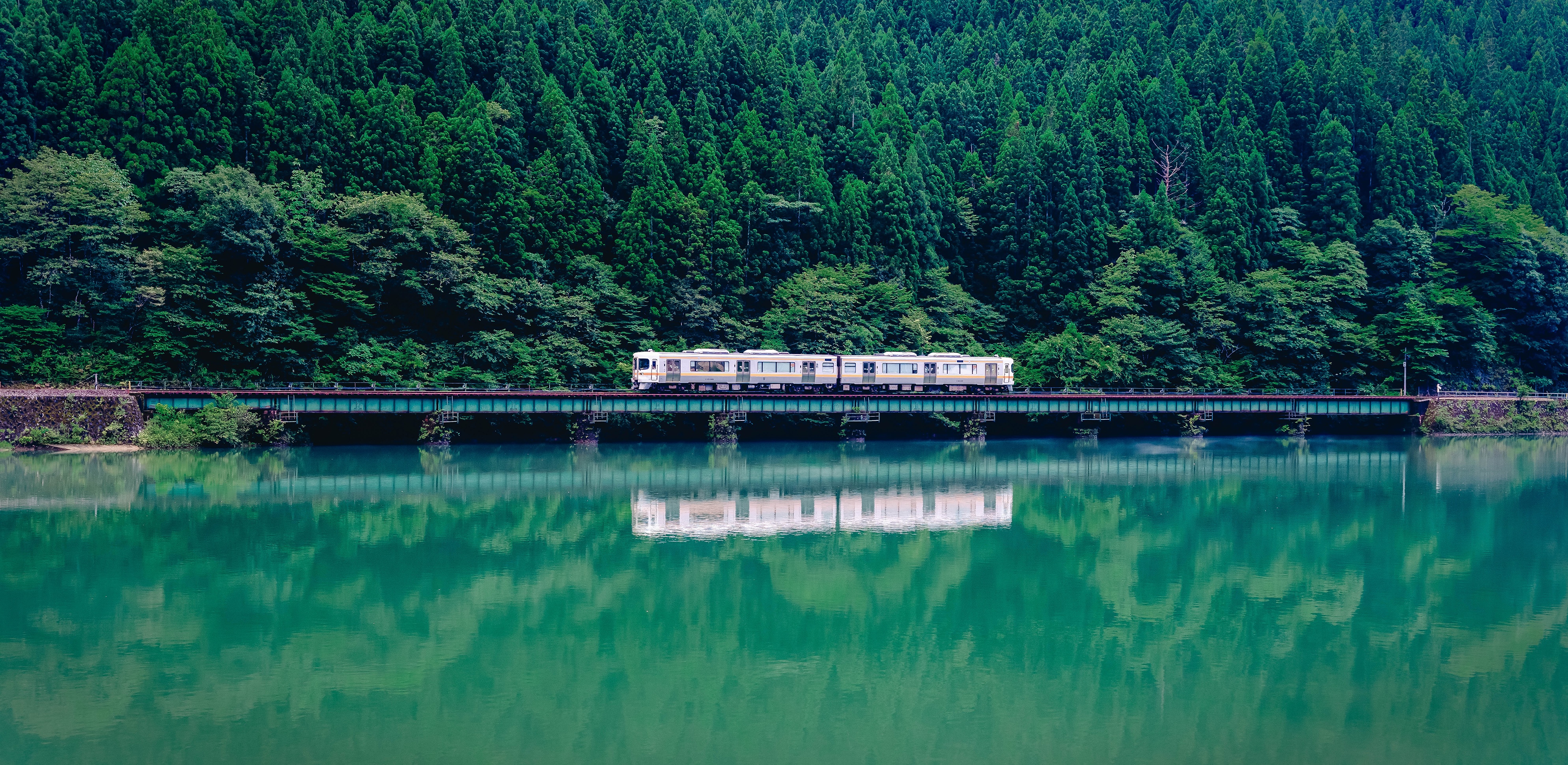 Train crossing a bridge over a lake in Japan HD Wallpaper