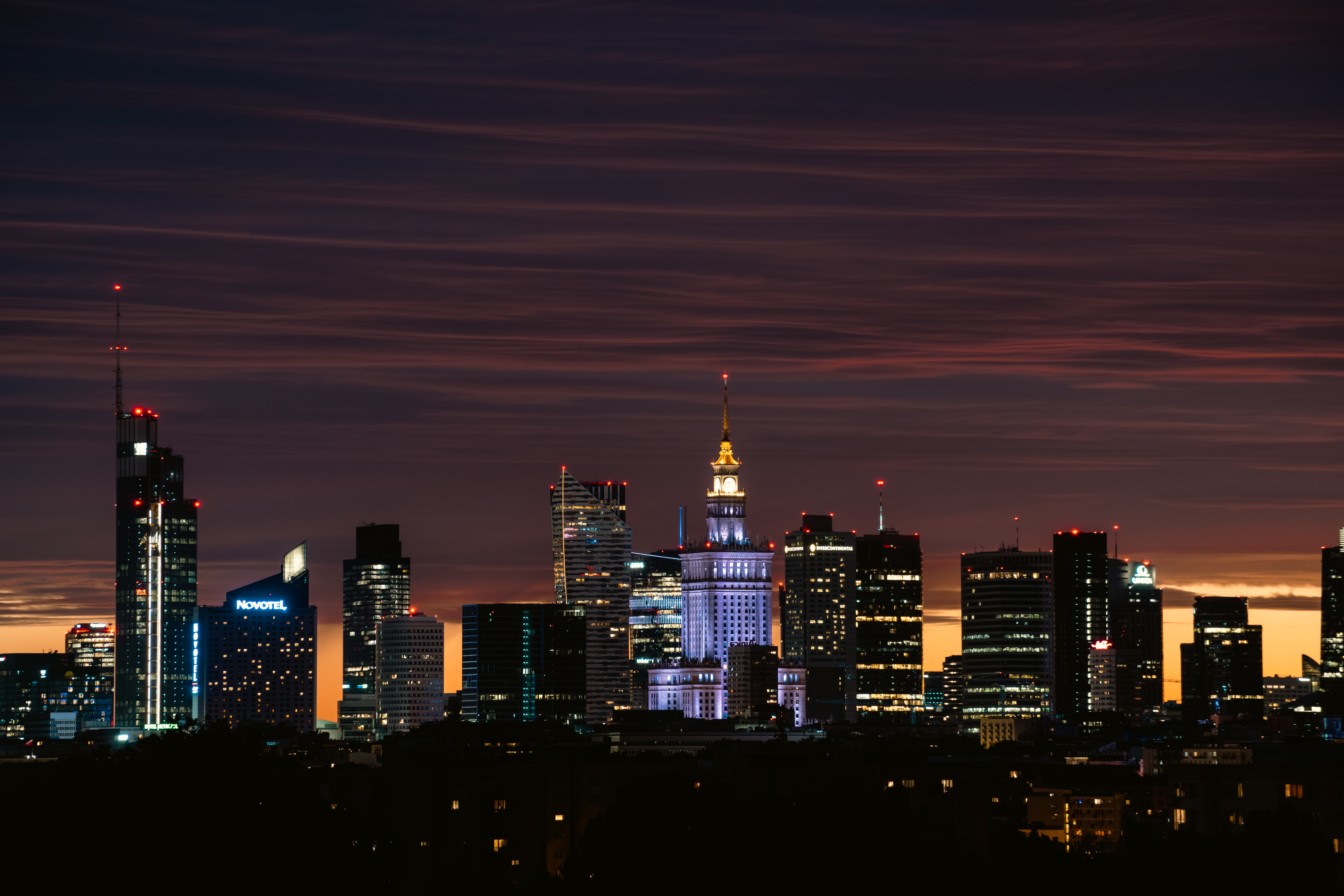City skyline at dusk with illuminated skyscrapers HD Wallpaper
