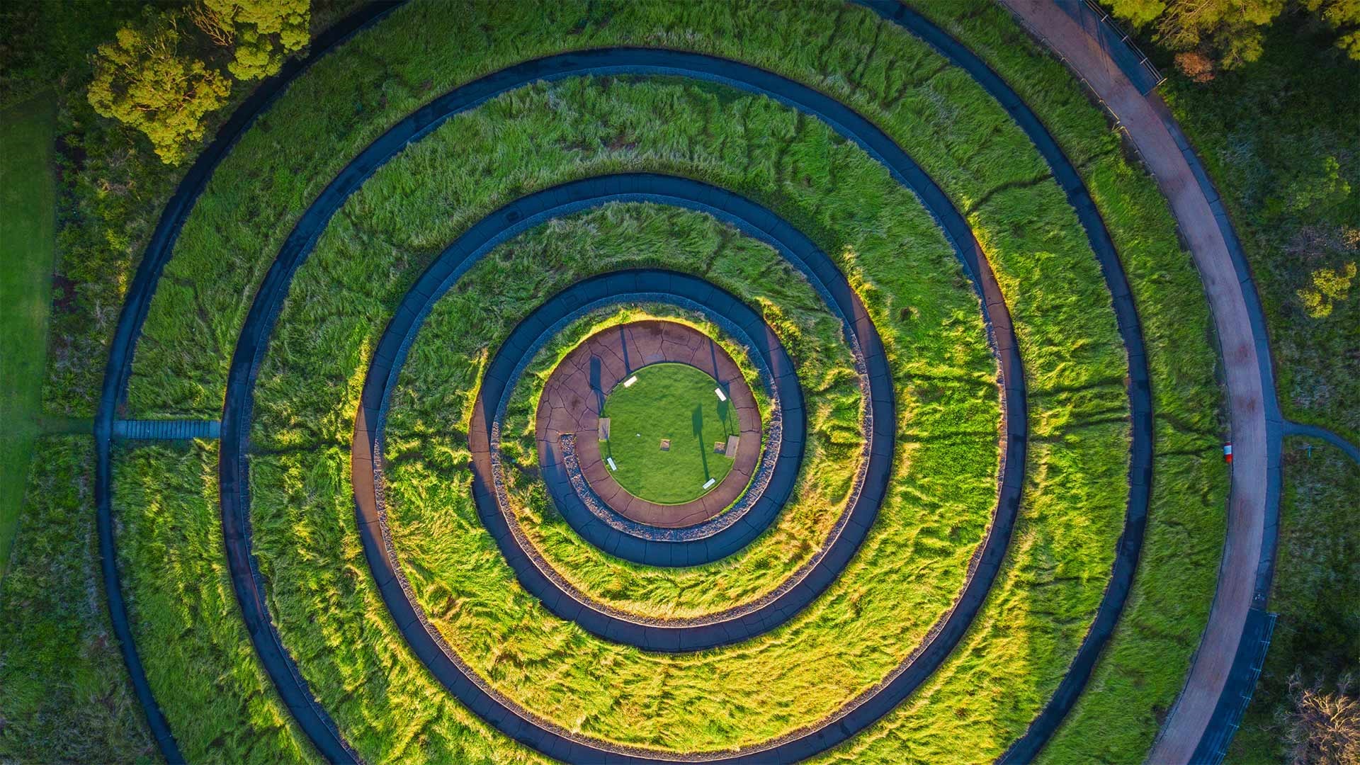 Aerial view of a spiral garden with grassy terraces HD Wallpaper