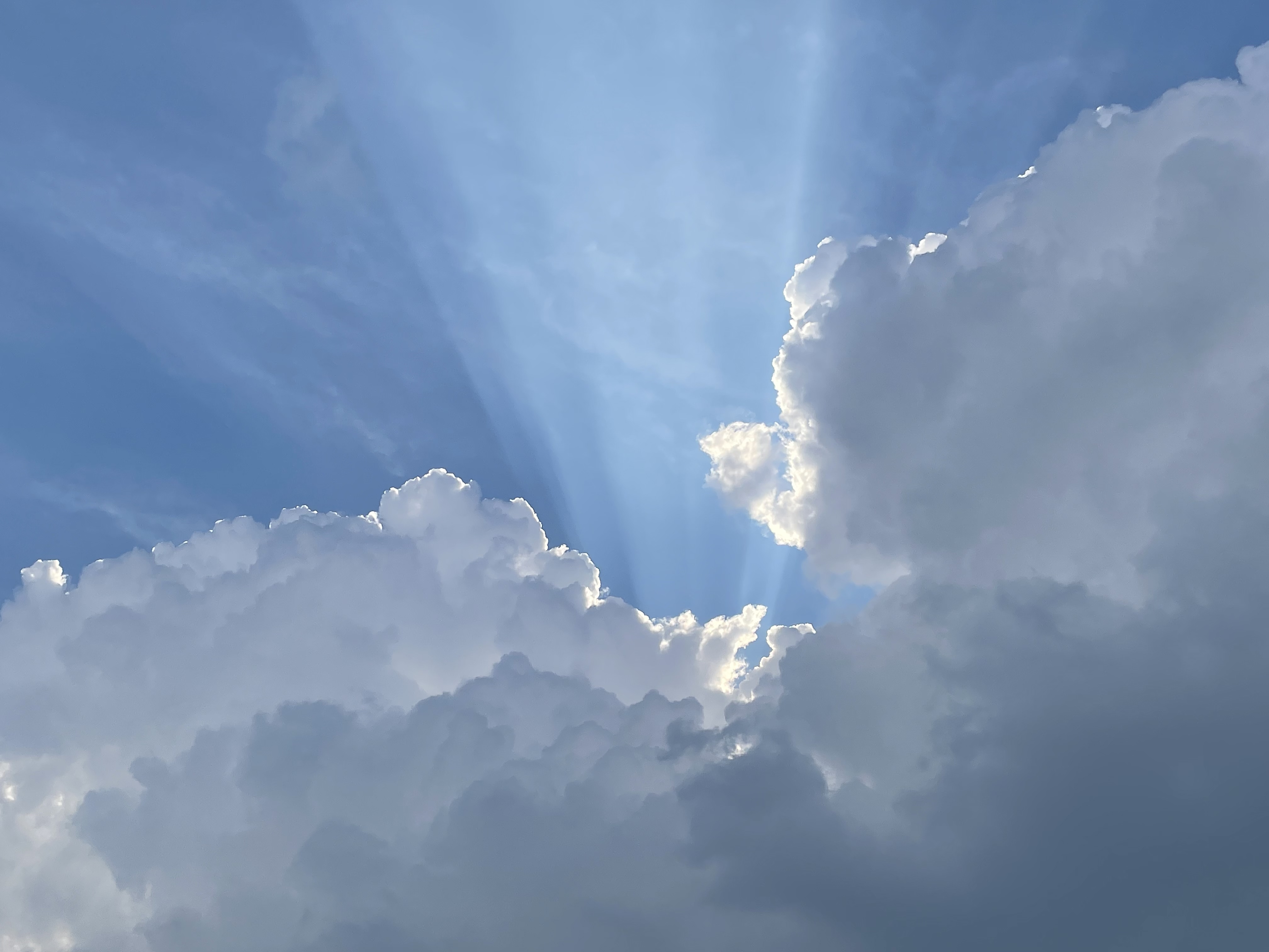 4K sunlight rays through clouds in blue sky HD Wallpaper
