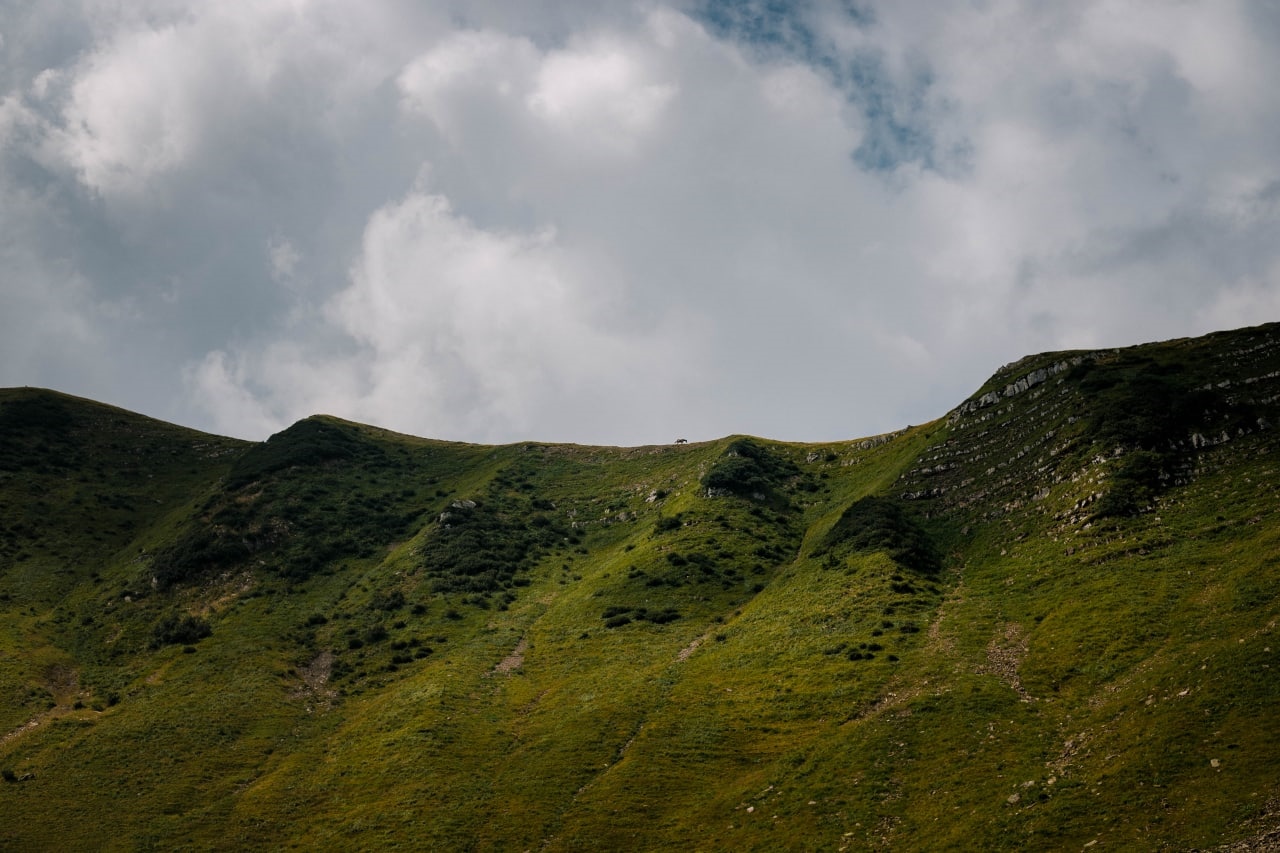 Green mountain range under cloudy sky in Russia HD Wallpaper