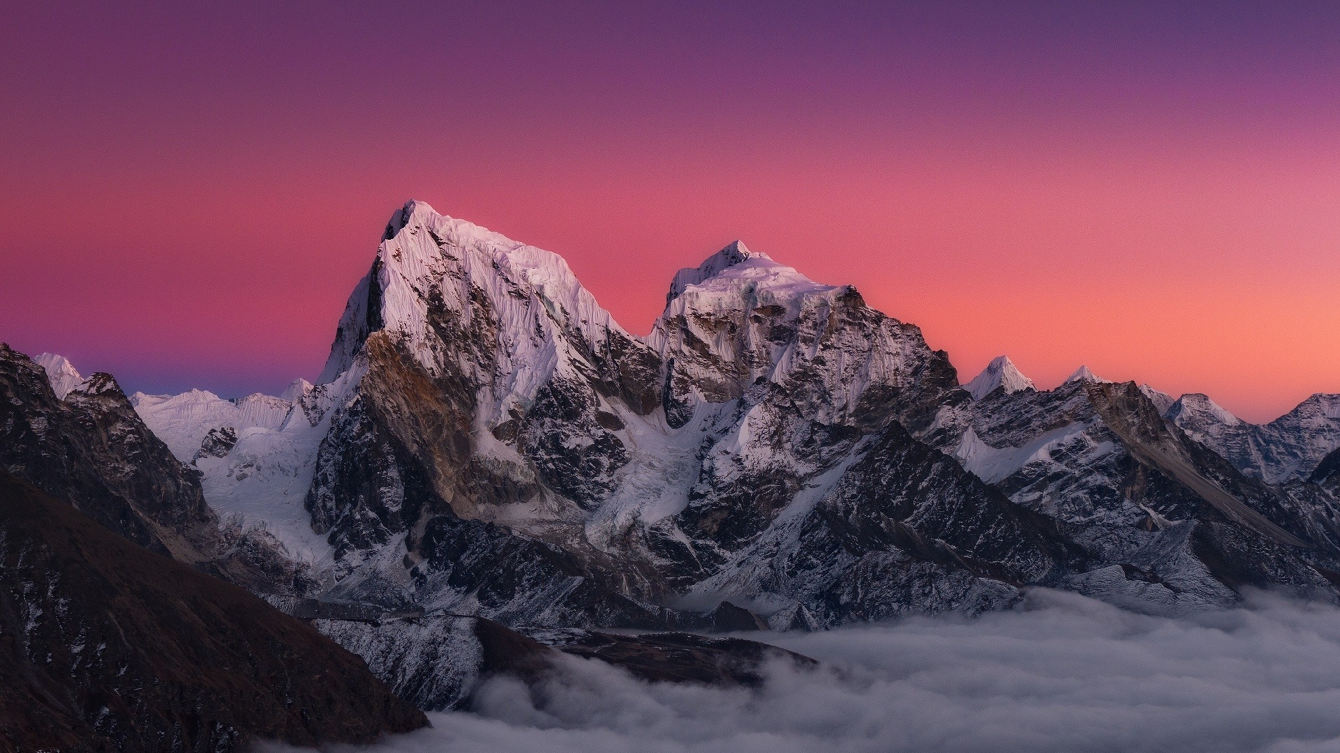 Snow-capped mountains under a vibrant sunset sky HD Wallpaper