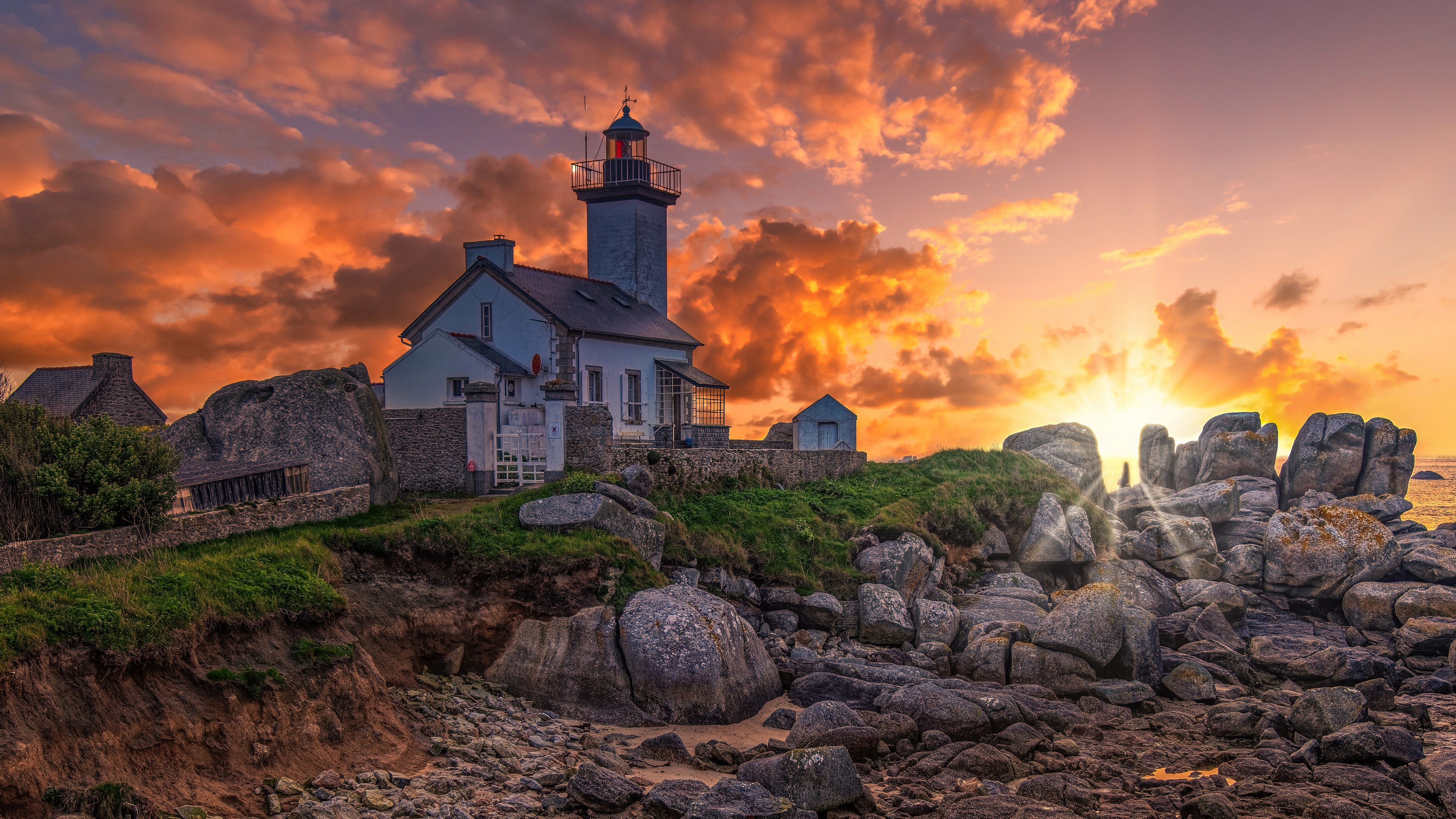 4K sunset over lighthouse on rocky coast of France HD Wallpaper