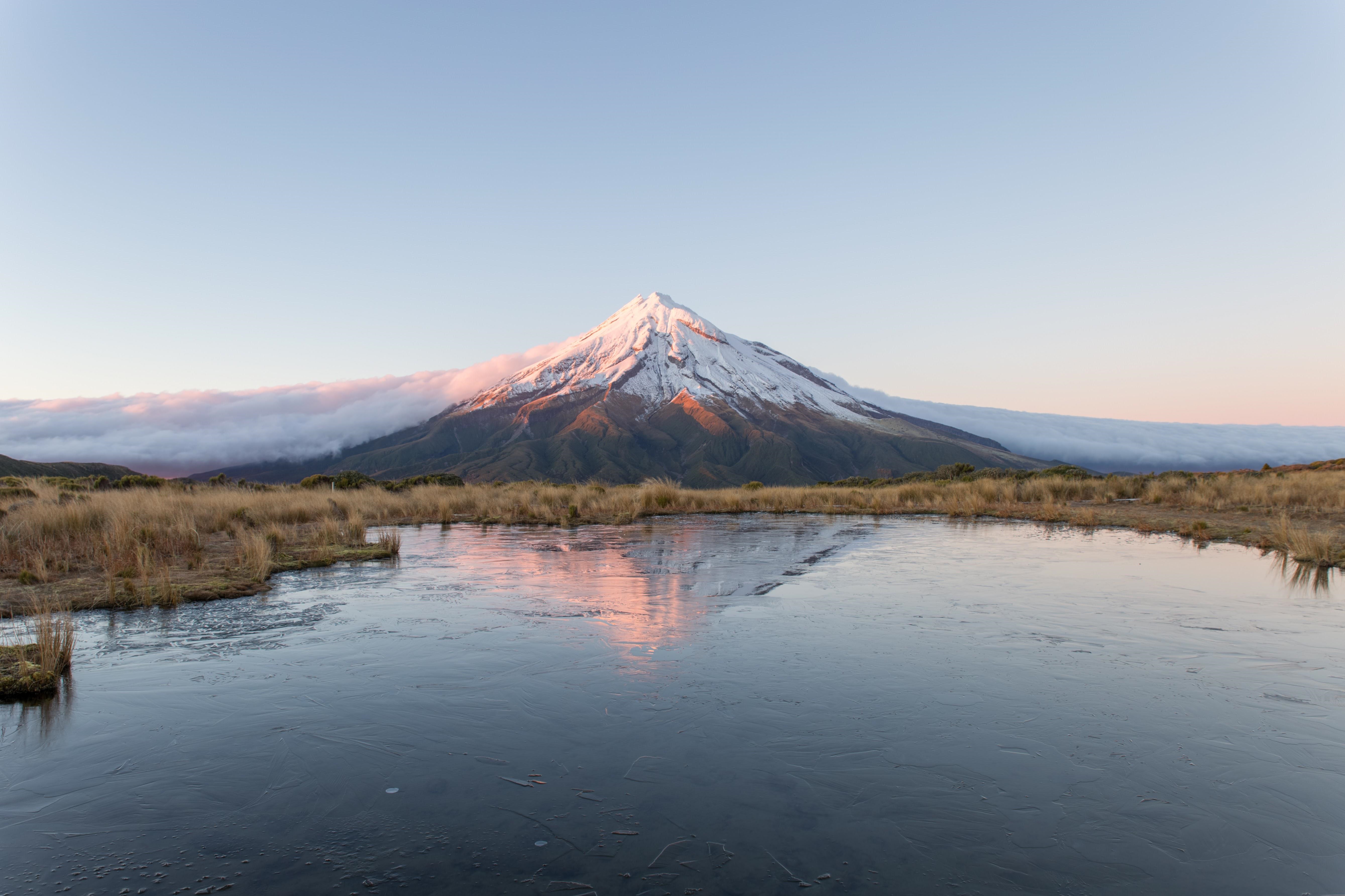 Mount Taranaki reflected in a frozen pond at sunrise HD Wallpaper