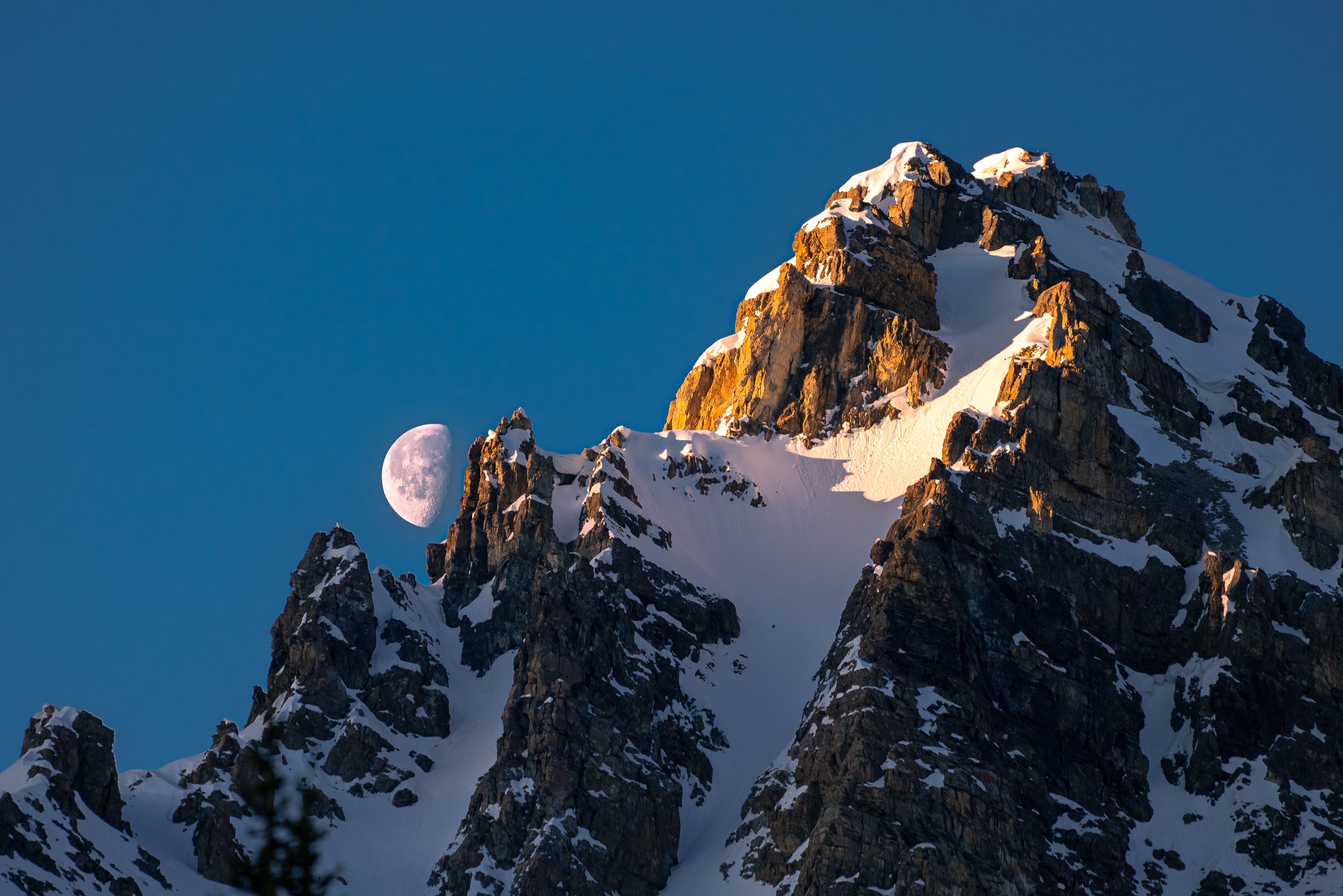 Moon over snow-covered mountain peak HD Wallpaper