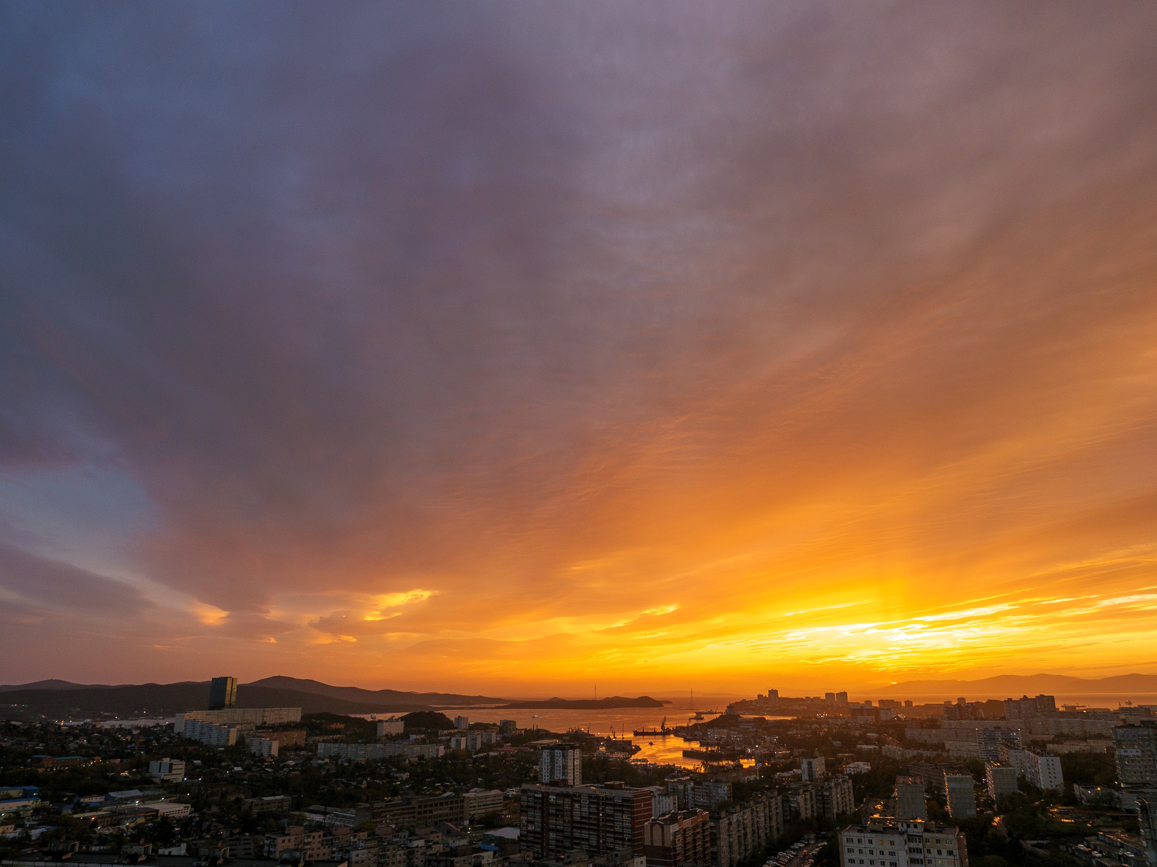 Cityscape at sunset with dramatic sky HD Wallpaper