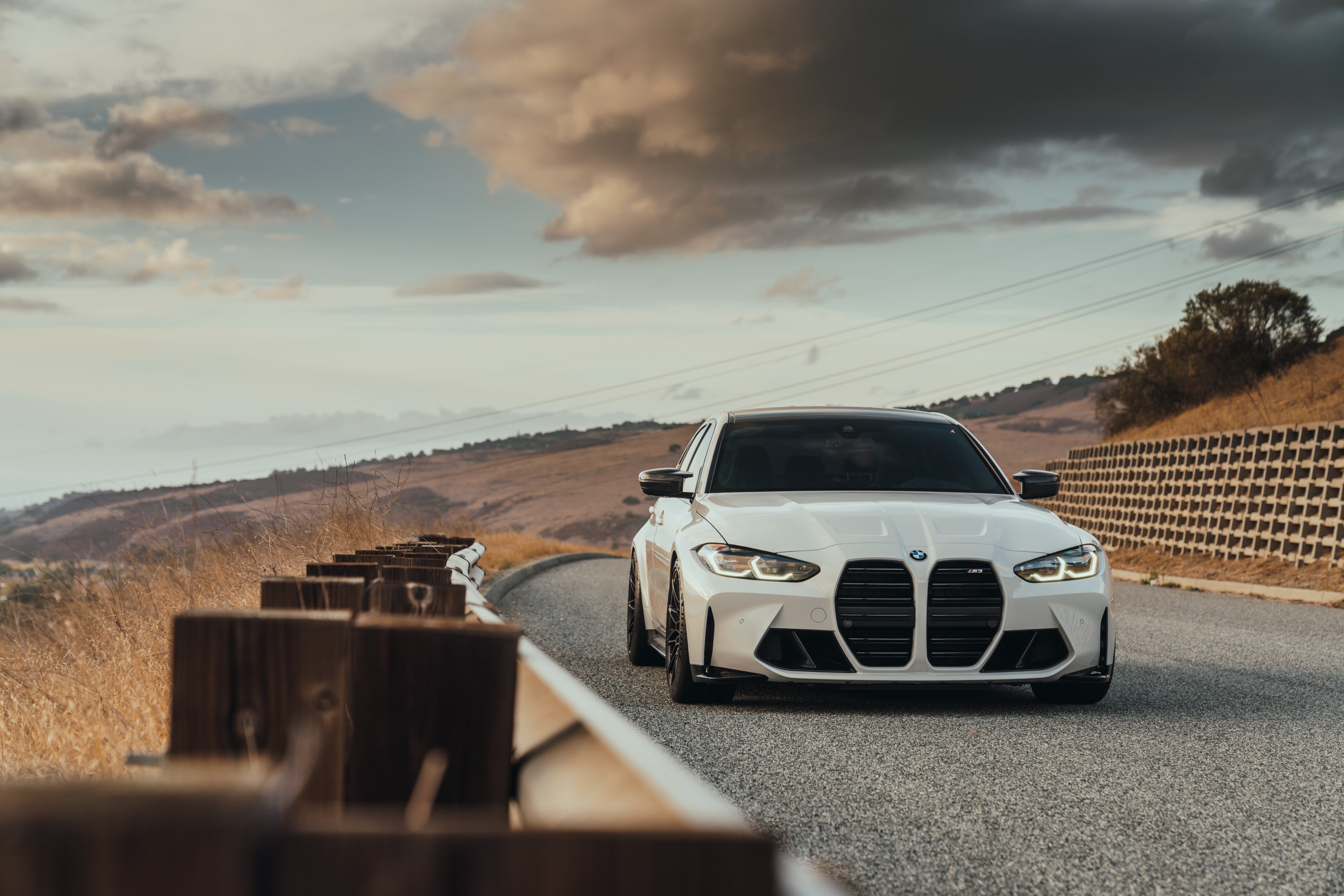 White BMW M3 G80 on a scenic road HD Wallpaper