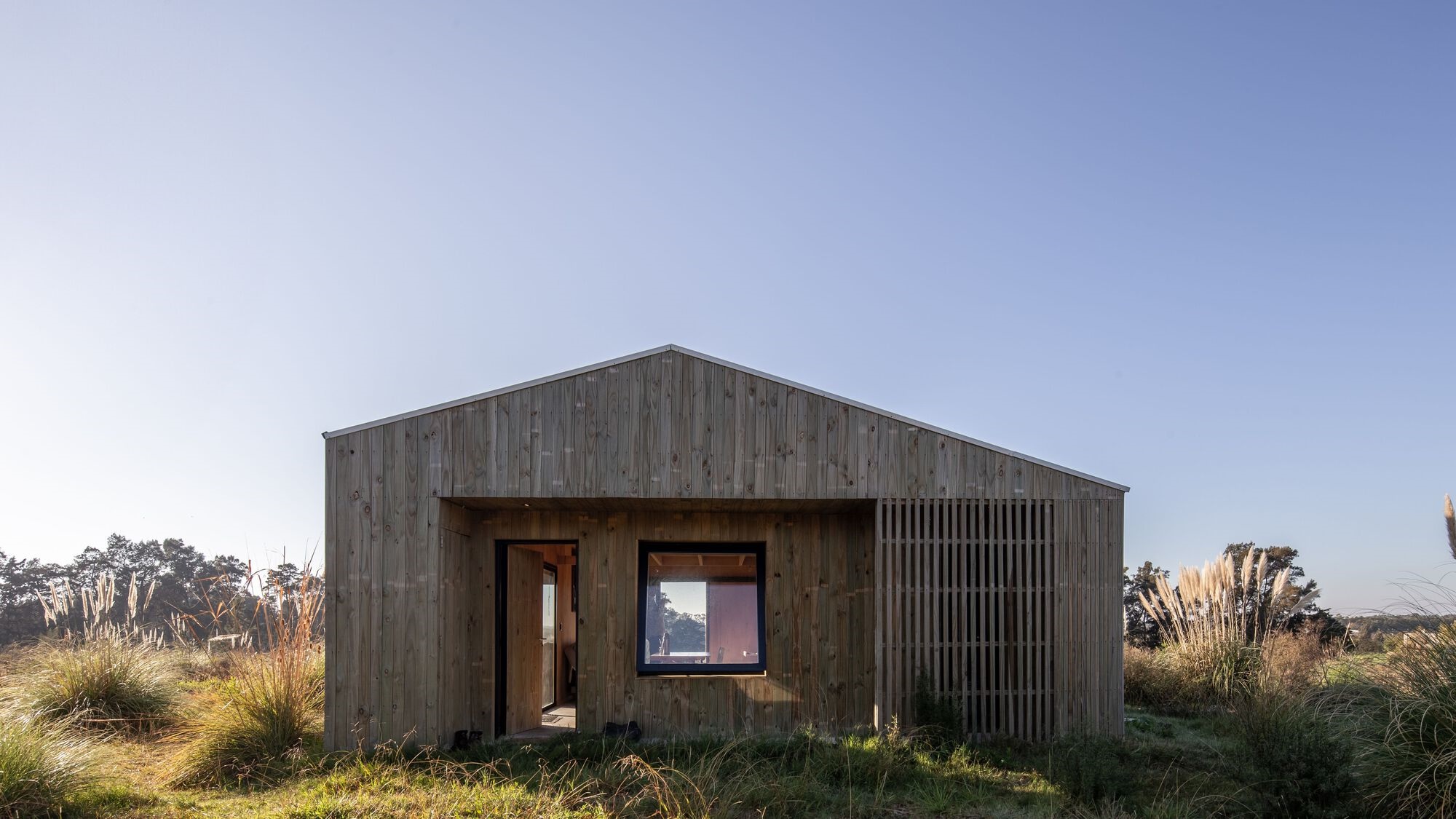 Wooden house facade in a grassy field HD Wallpaper