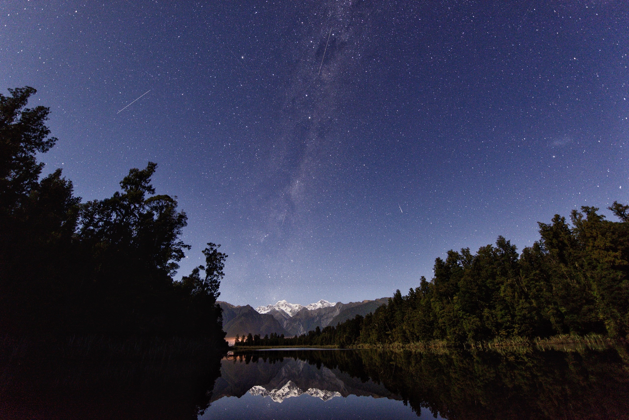 Starry night over a lake with mountains and trees HD Wallpaper