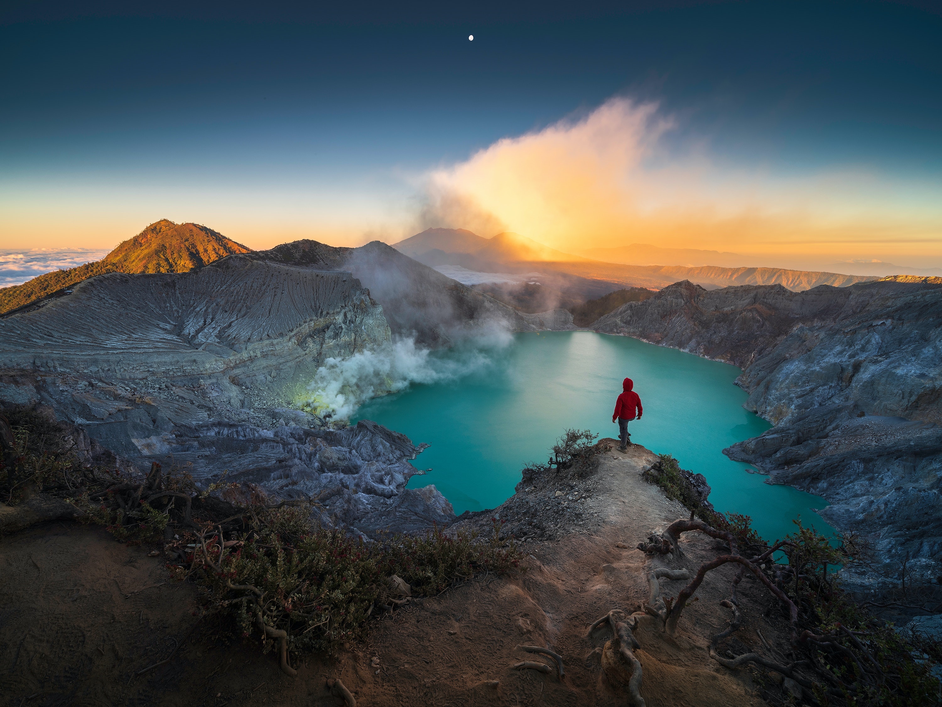 Mount Ijen crater lake at sunrise with a lone hiker HD Wallpaper