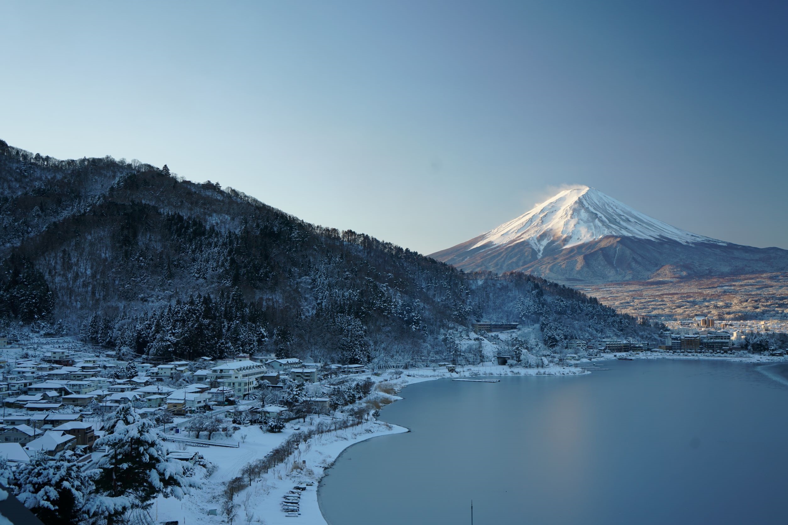 Mount Fuji and a snow-covered village by a frozen lake HD Wallpaper