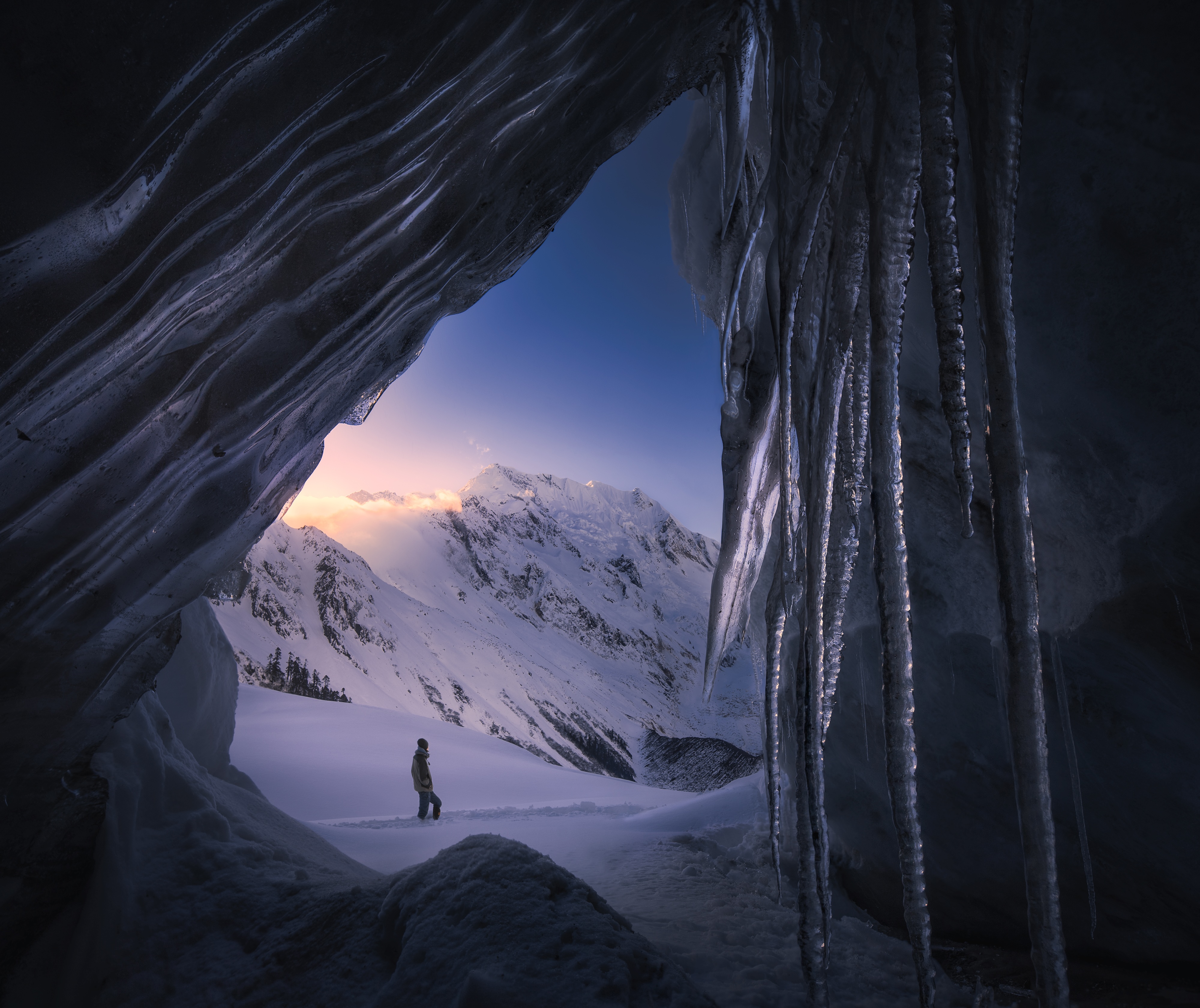 Man standing in snowy landscape viewed from ice cave in Tibet HD Wallpaper