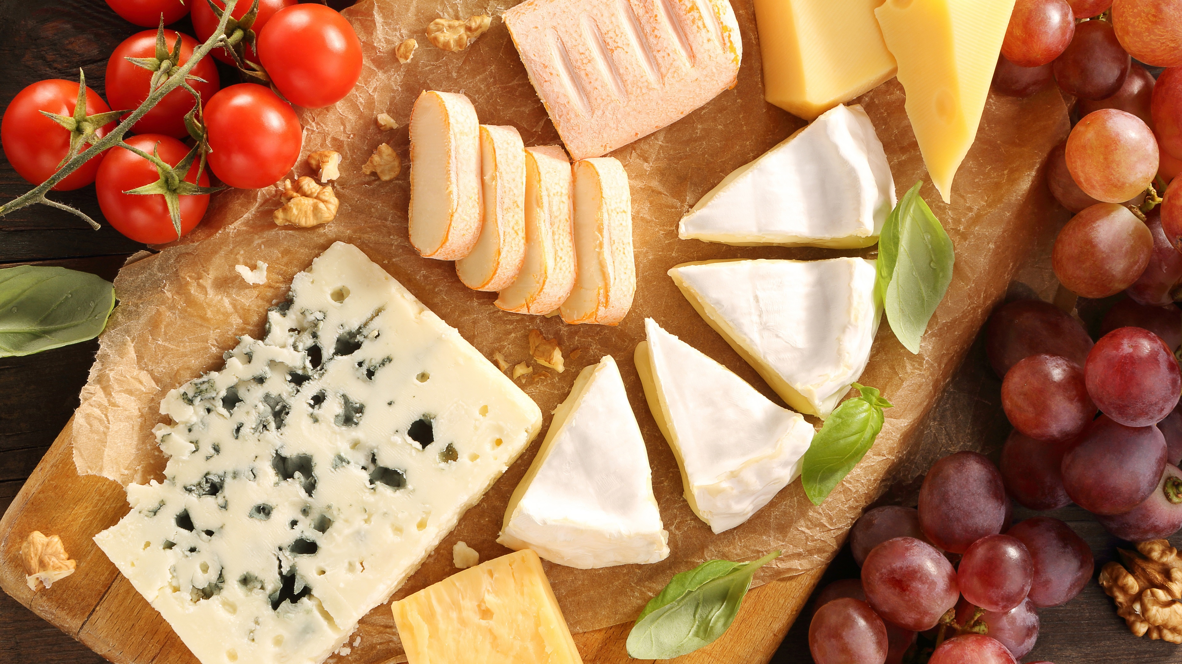 Cheese platter with tomatoes, grapes, and nuts HD Wallpaper
