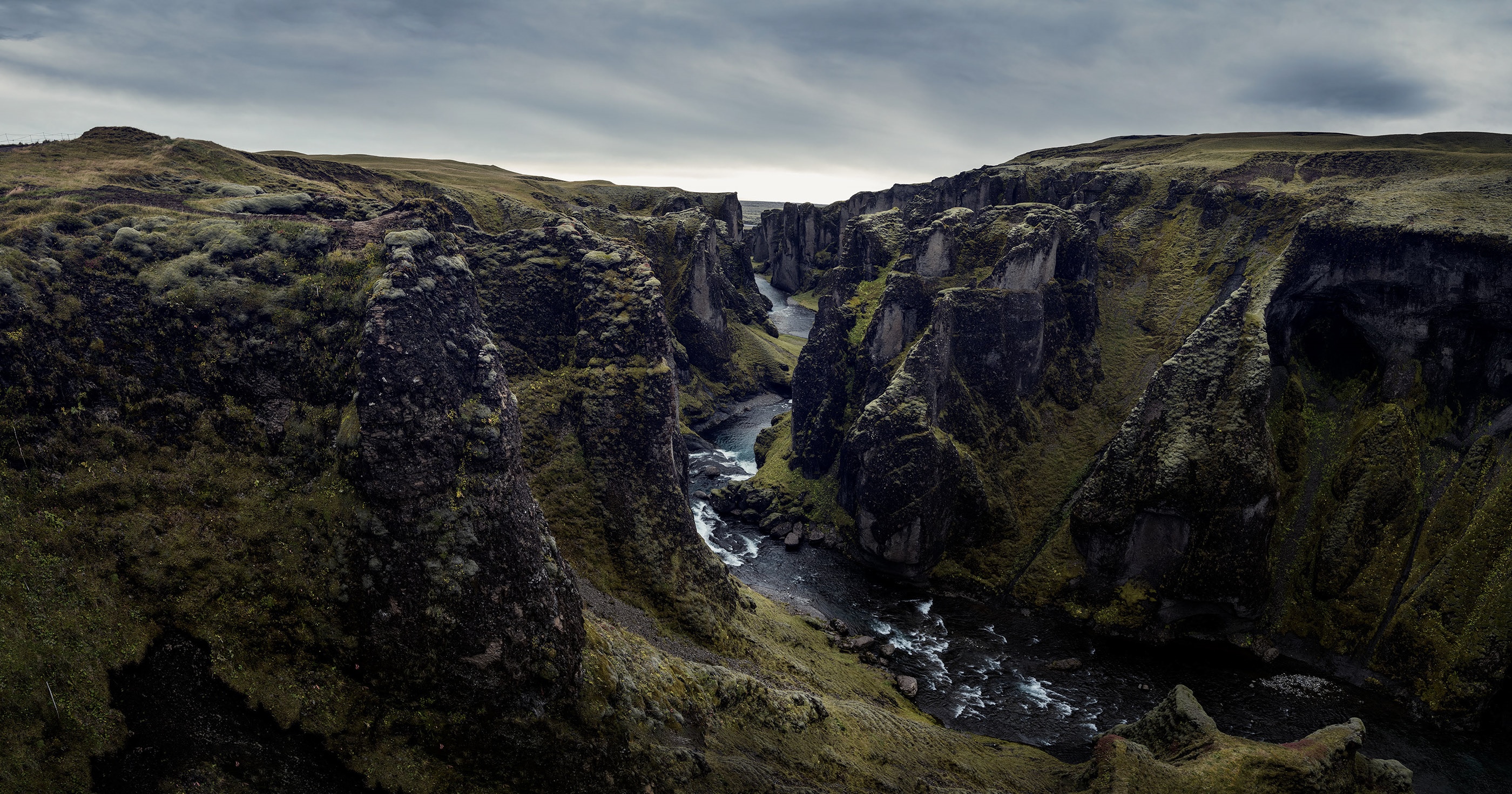 Fjaðrárgljúfur canyon in Iceland with a river flowing through HD Wallpaper