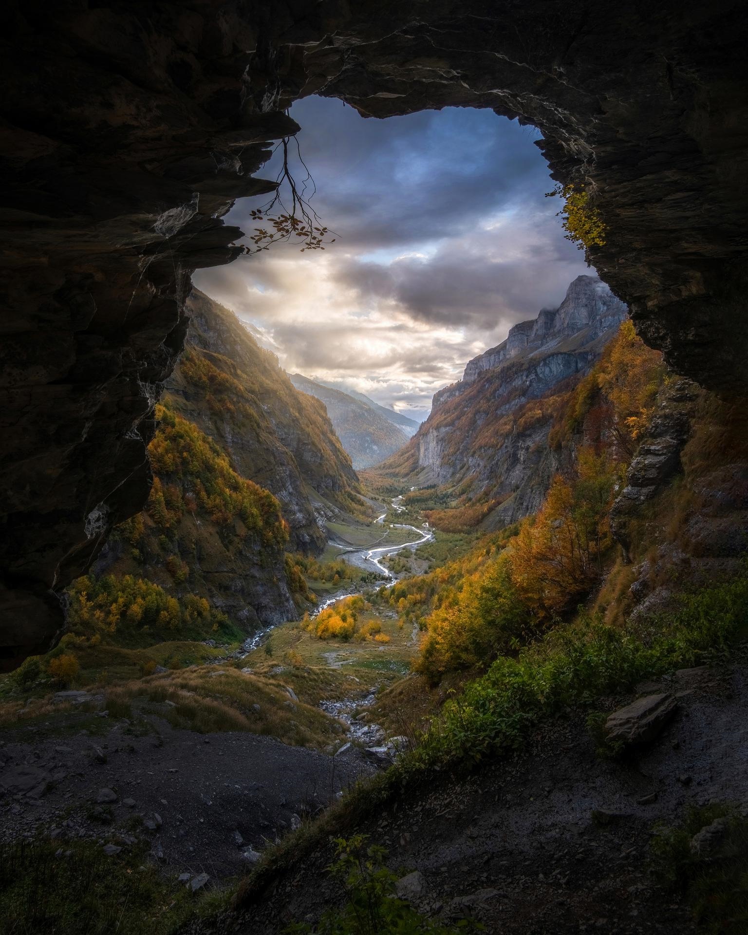 View of a valley with a river from a cave entrance HD Phone Wallpaper